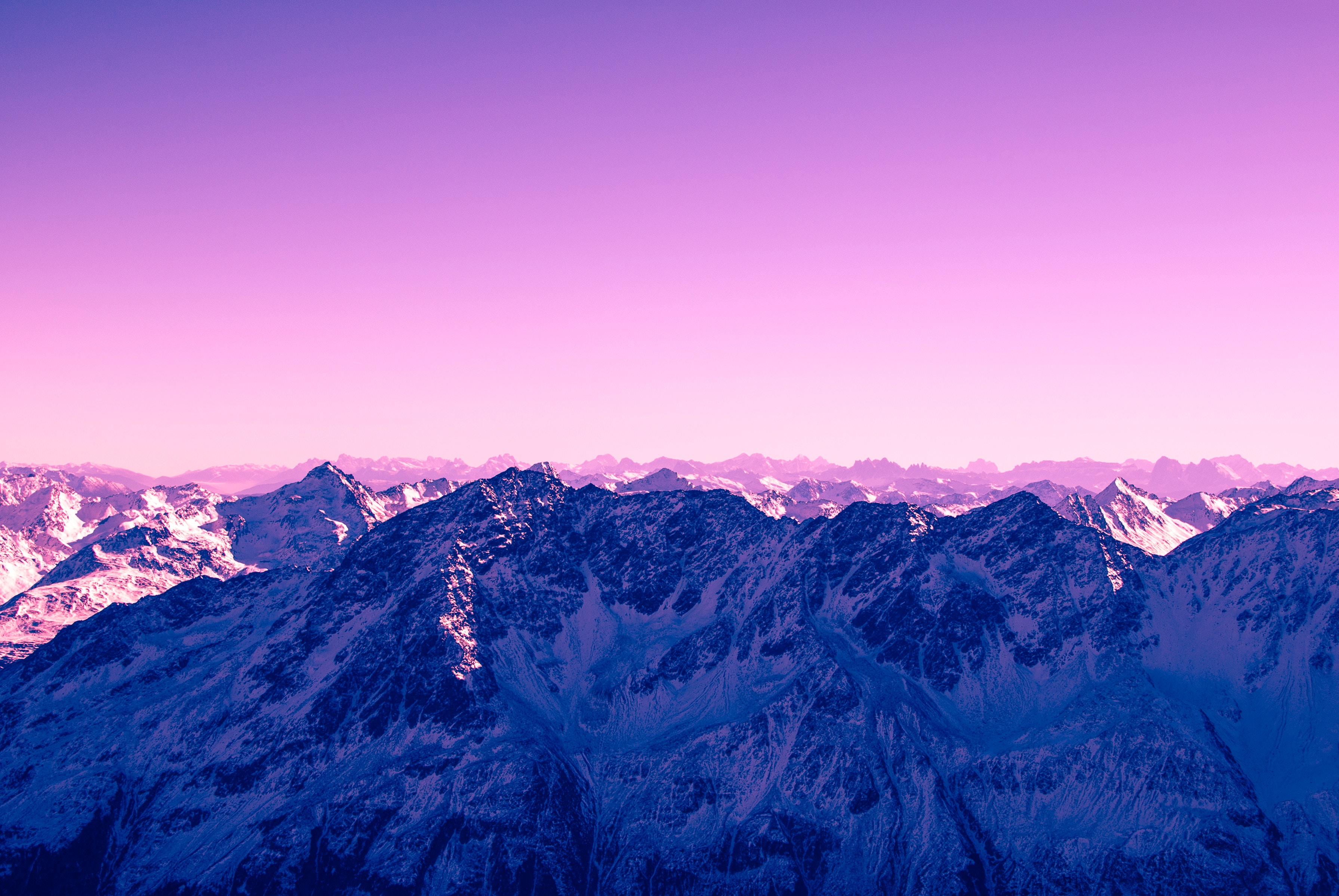 Snow-capped mountain range under a violet sky HD Wallpaper
