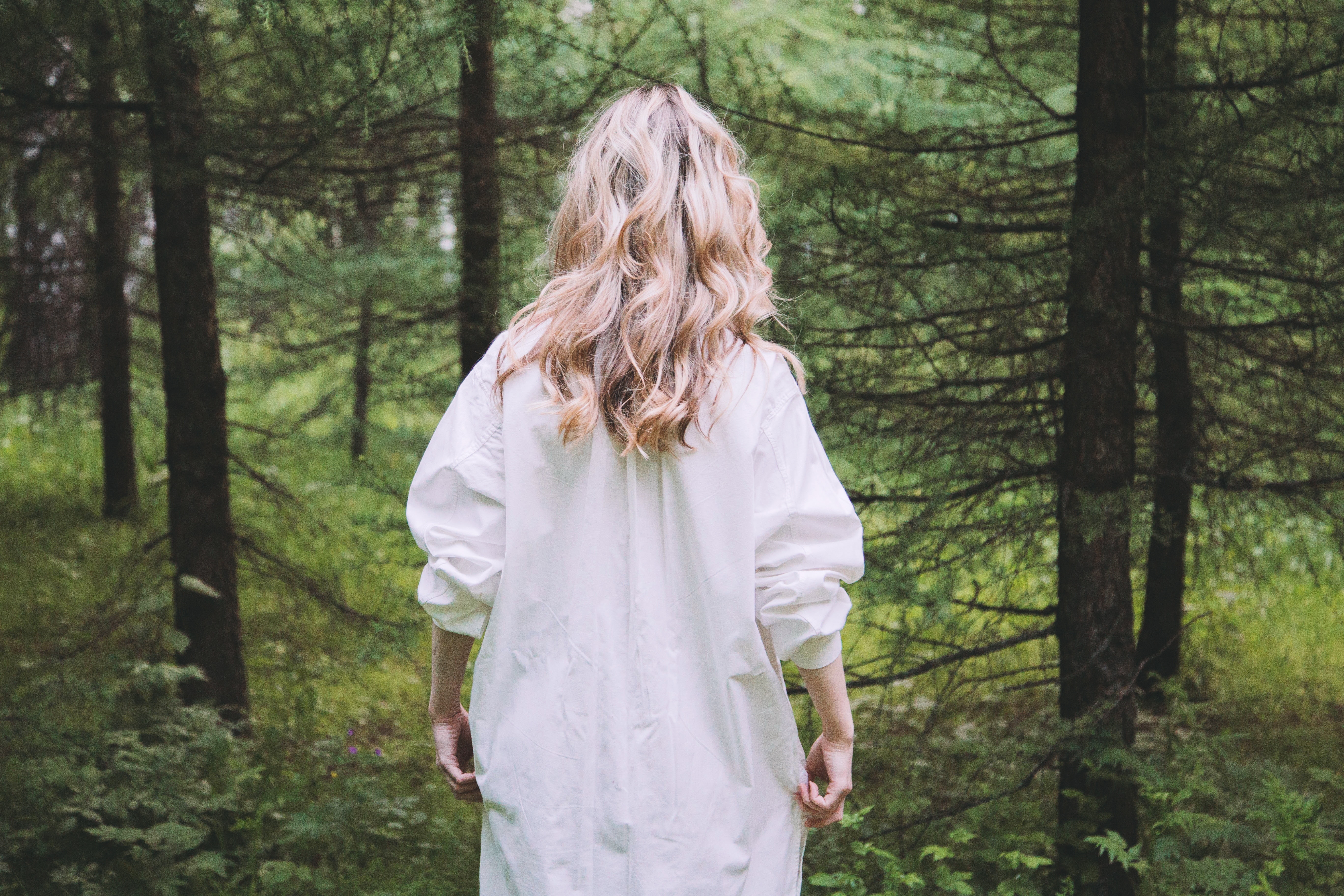 Woman in white shirt walking in a forest HD Wallpaper