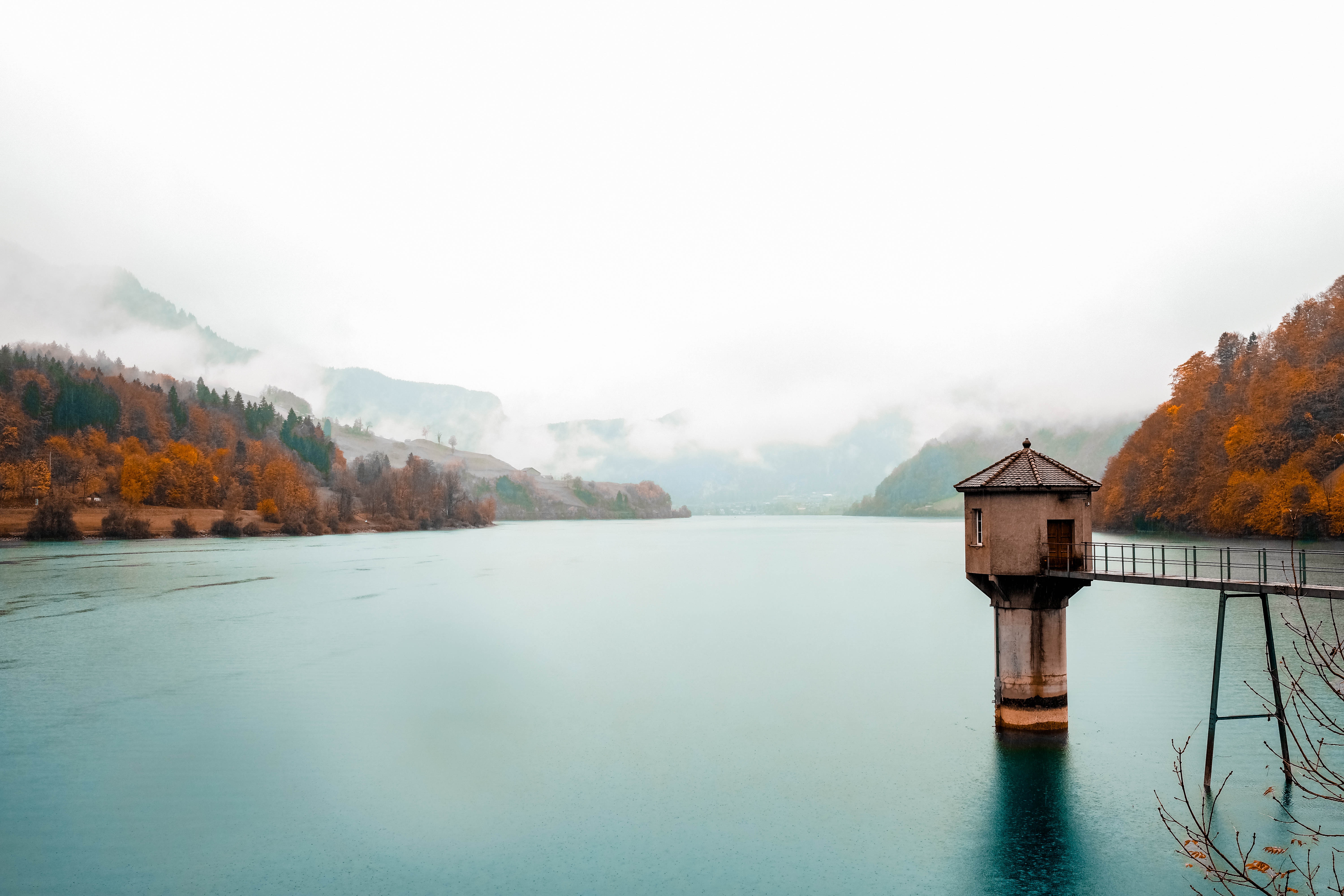 Tower in a lake with misty mountains and autumn trees HD Wallpaper