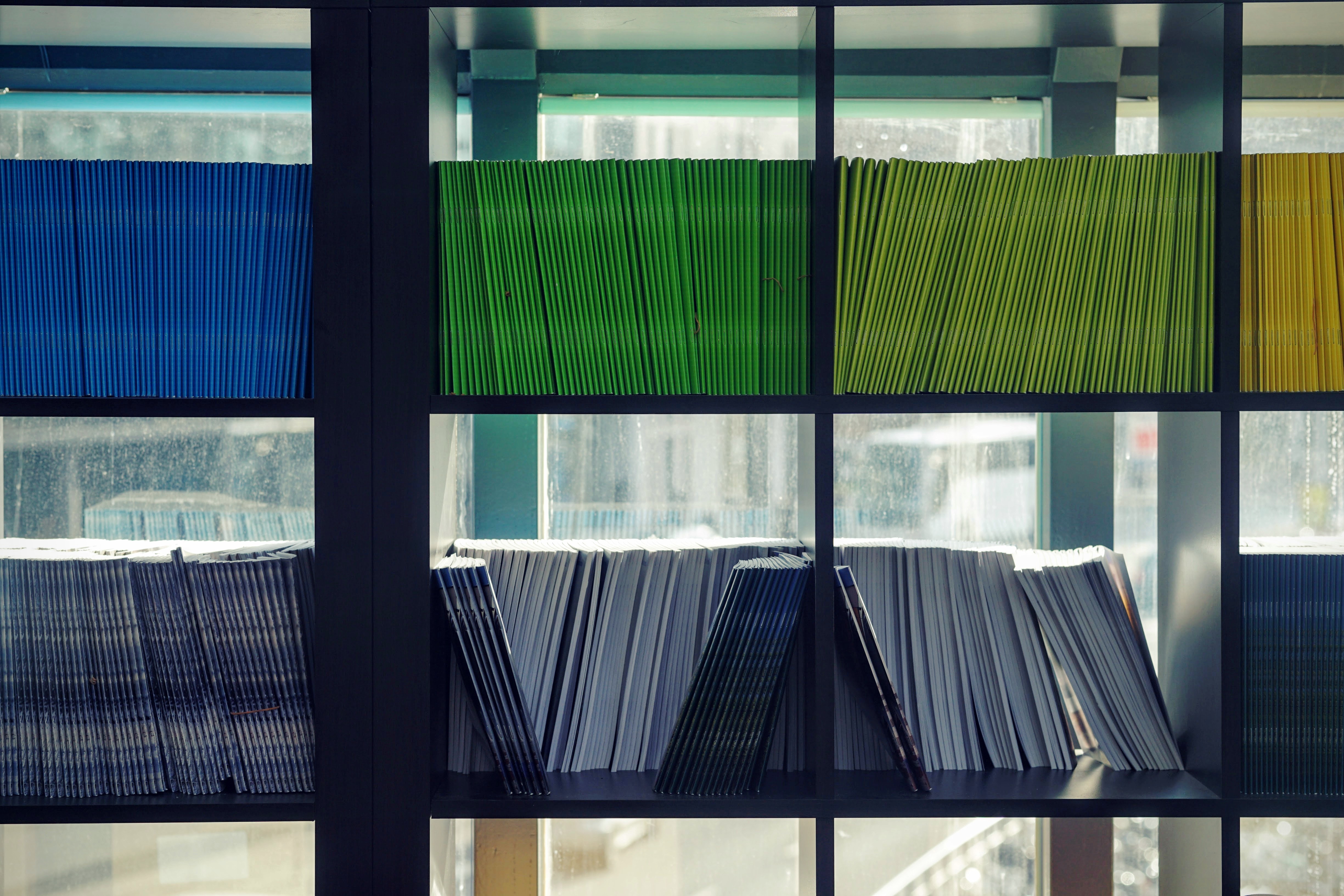 Bookshelf with colorful files and magazines HD Wallpaper