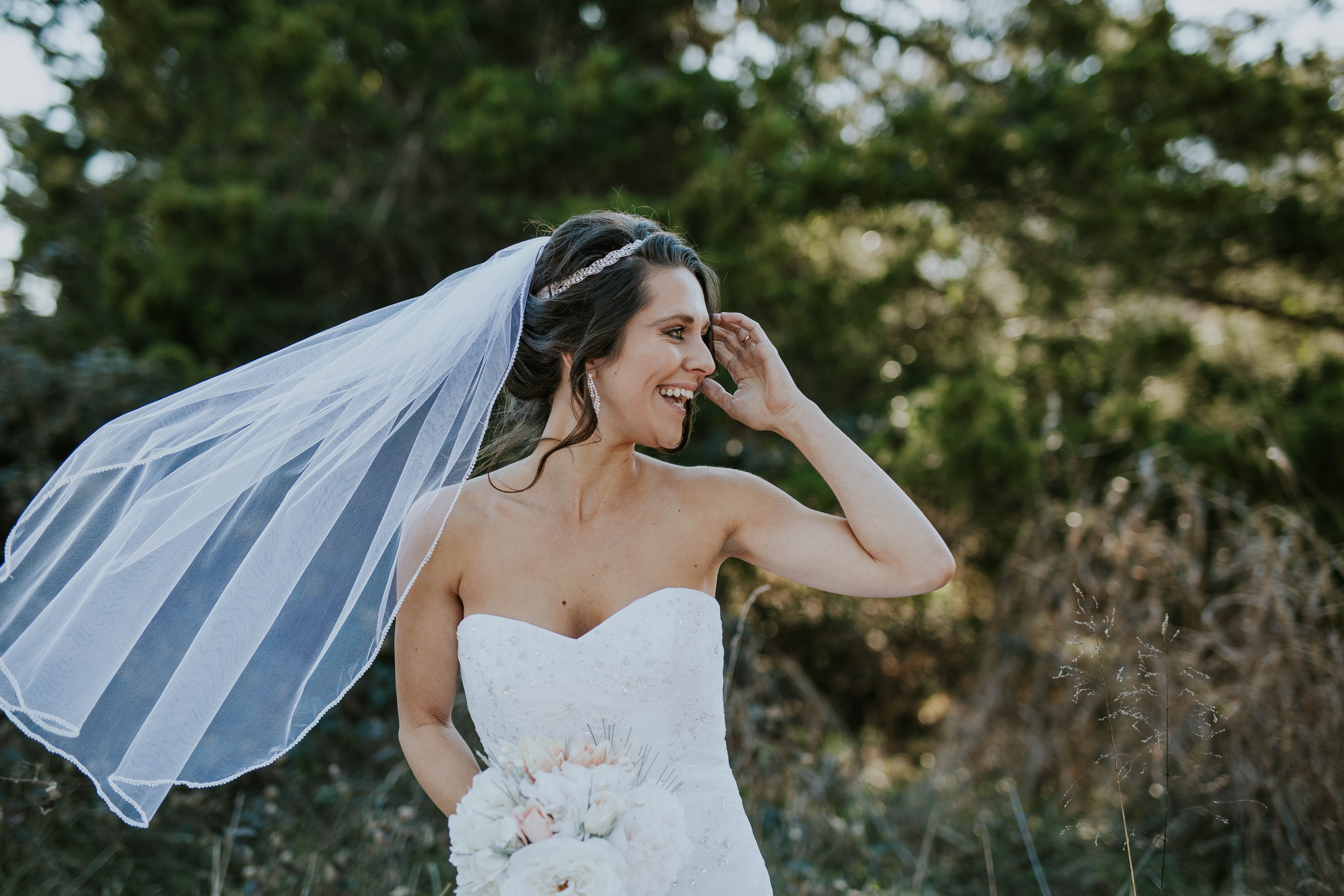 Bride laughing with veil and bouquet HD Wallpaper
