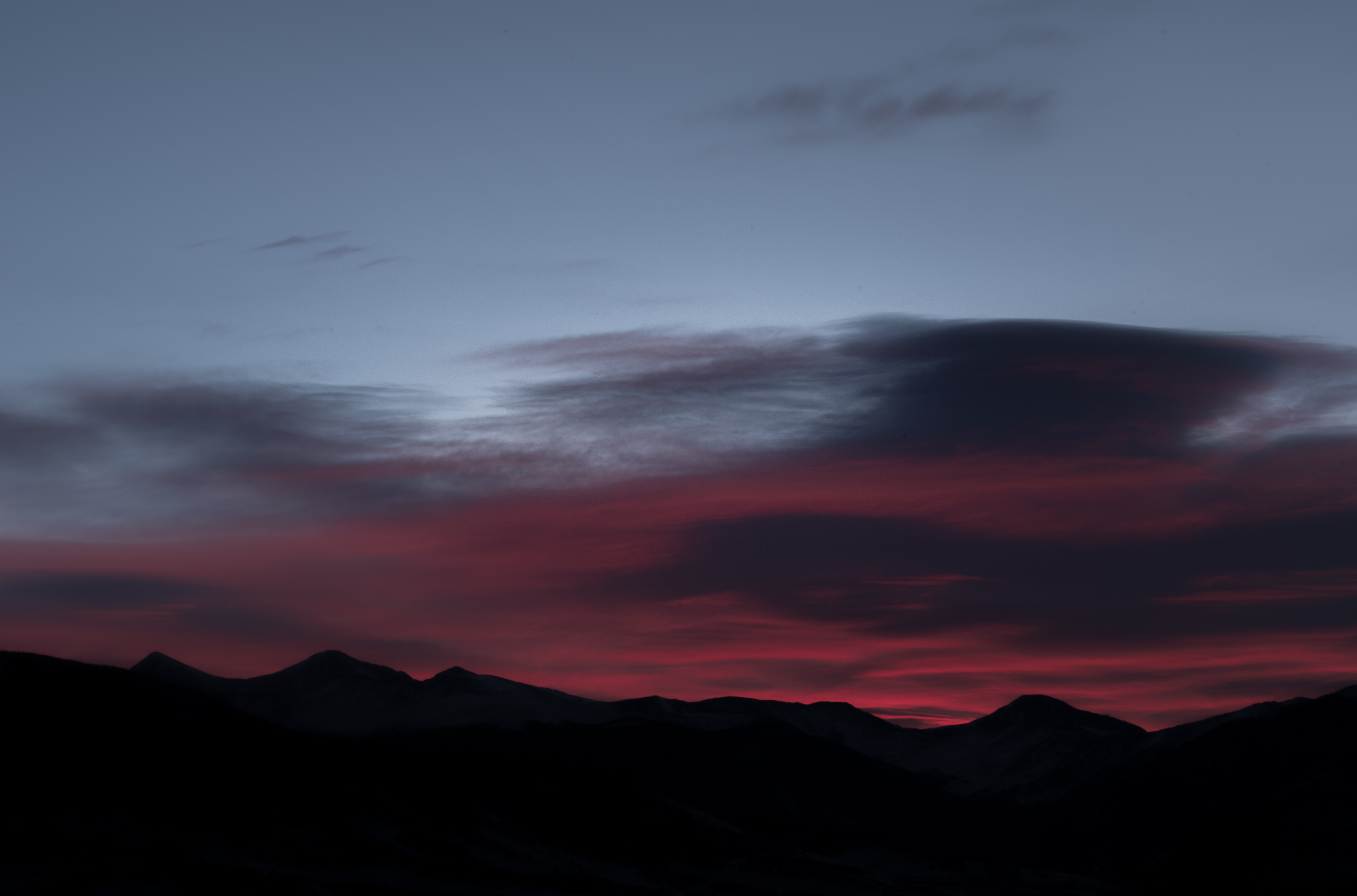 Silhouette of mountain range at dusk with colorful clouds HD Wallpaper