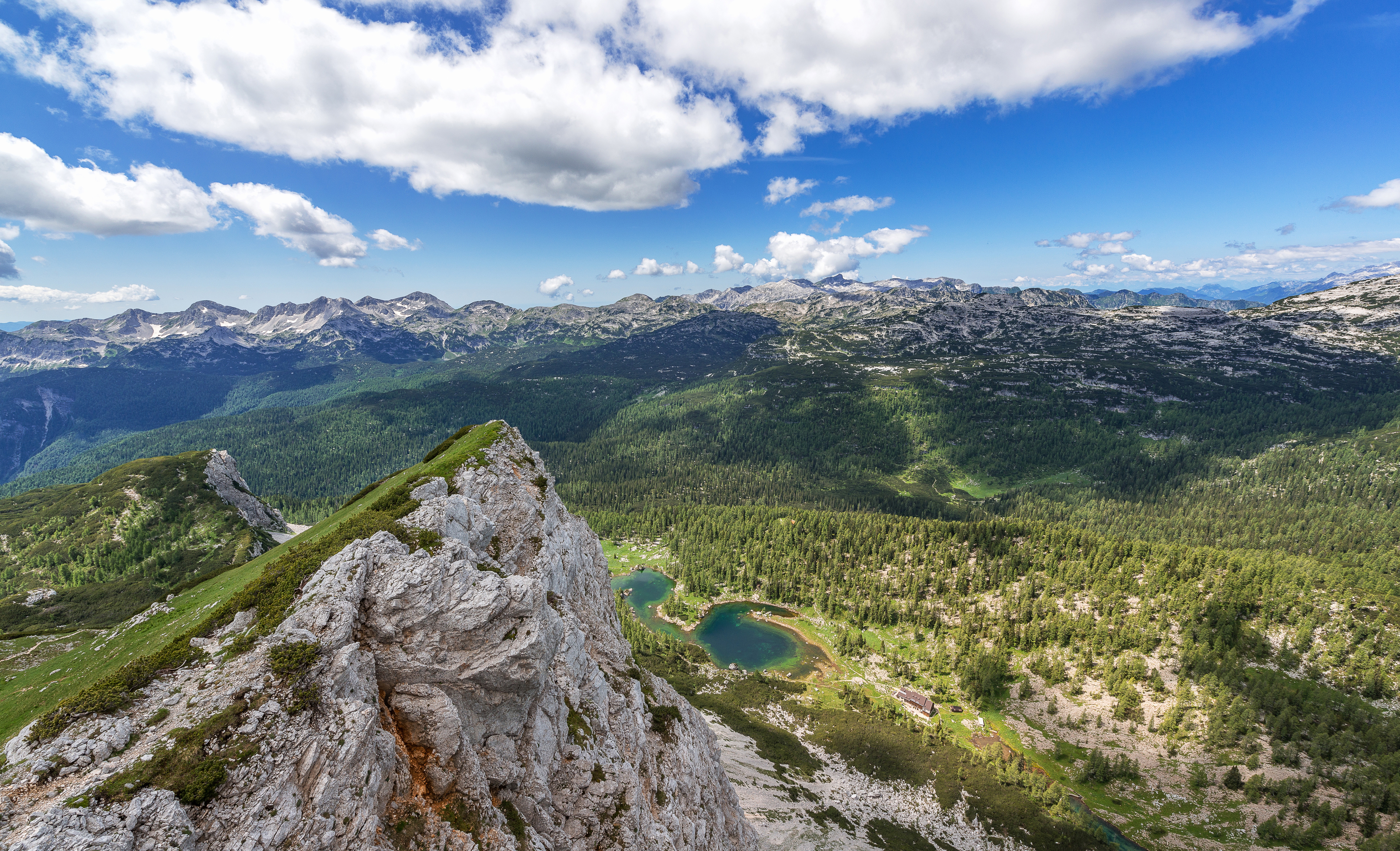 Rocky mountain range with green forests and lakes HD Wallpaper