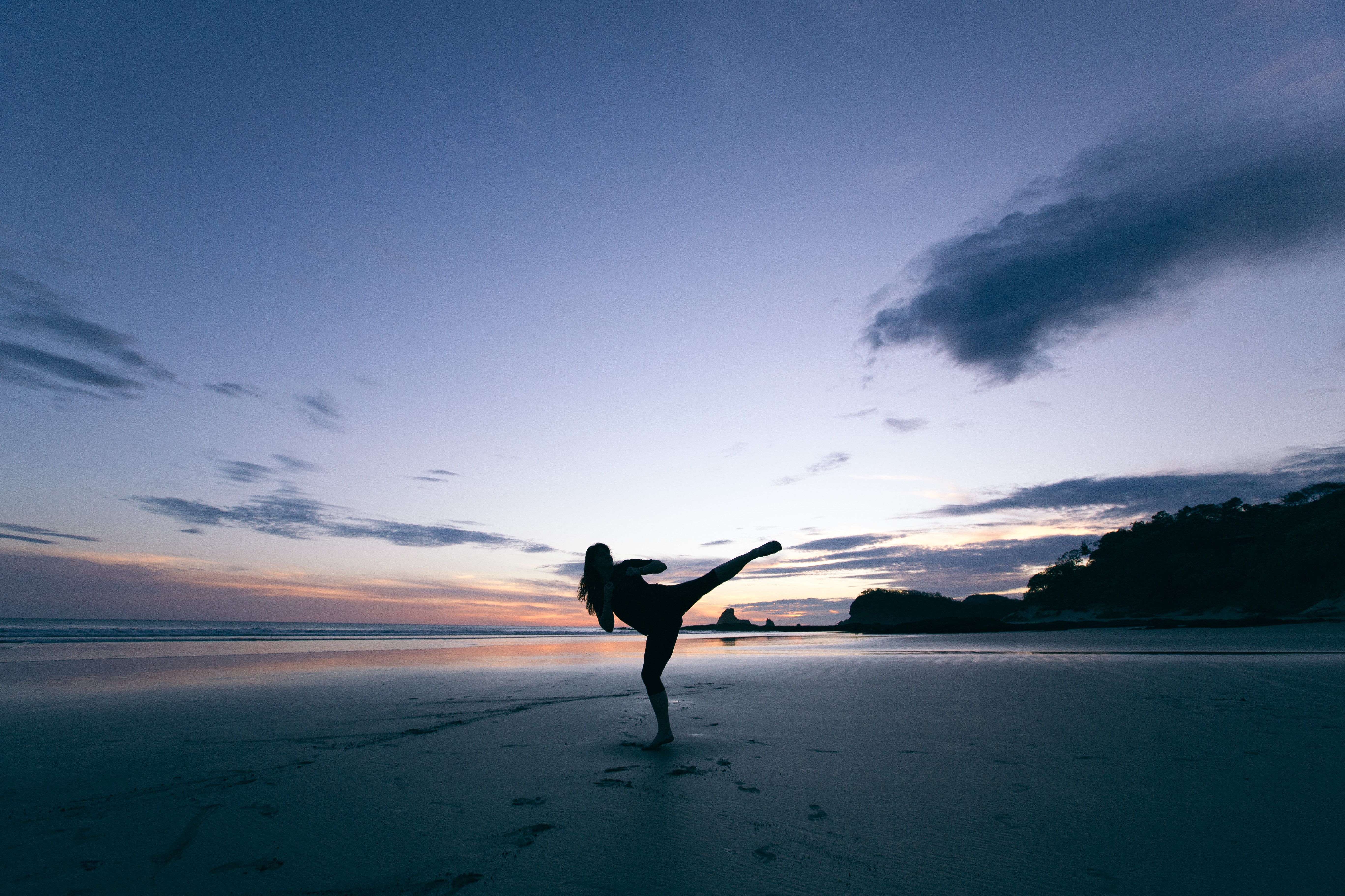 Woman practicing martial arts on a beach at sunset HD Wallpaper