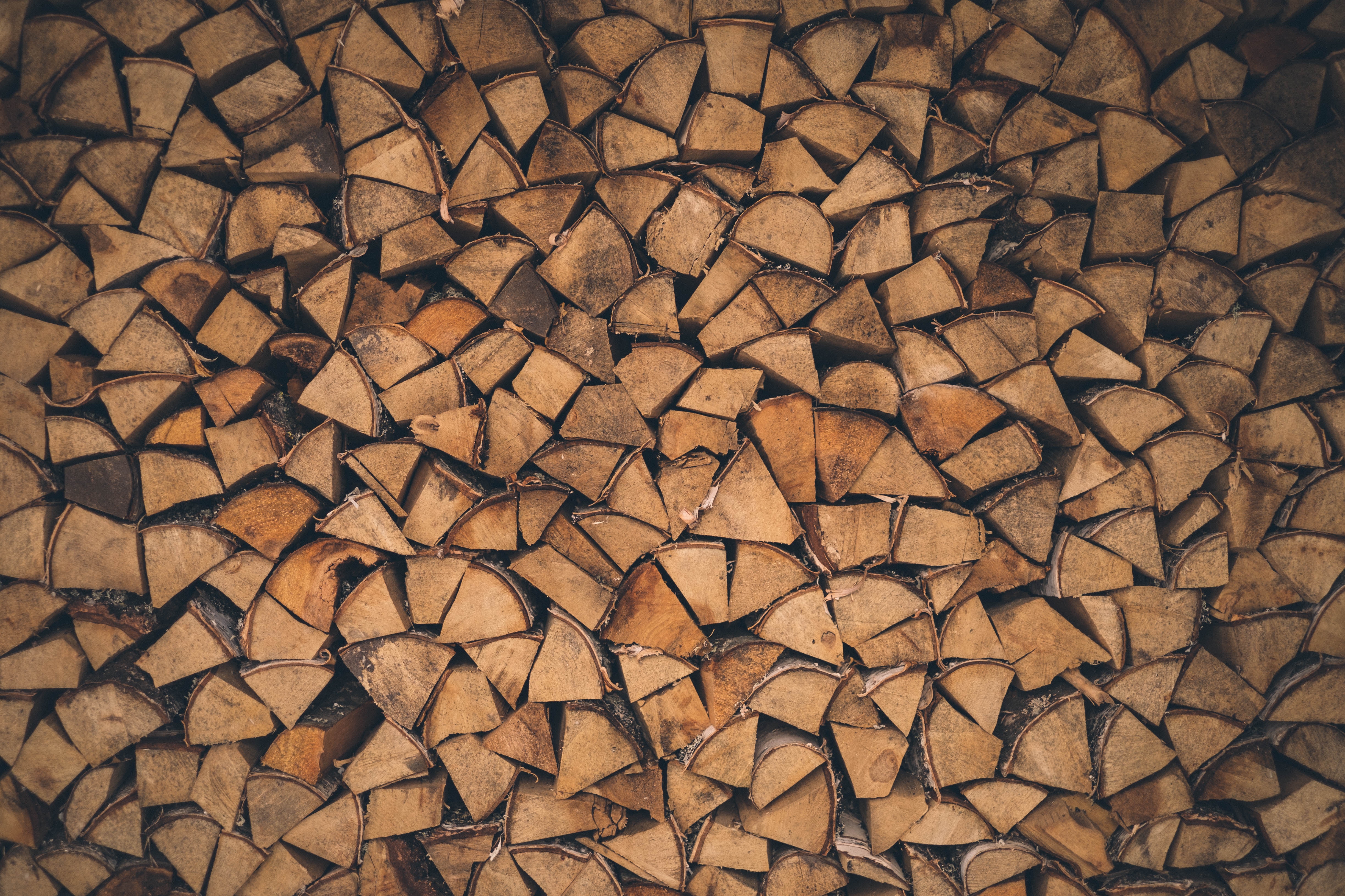 Stacked firewood pile with a brown pattern HD Wallpaper