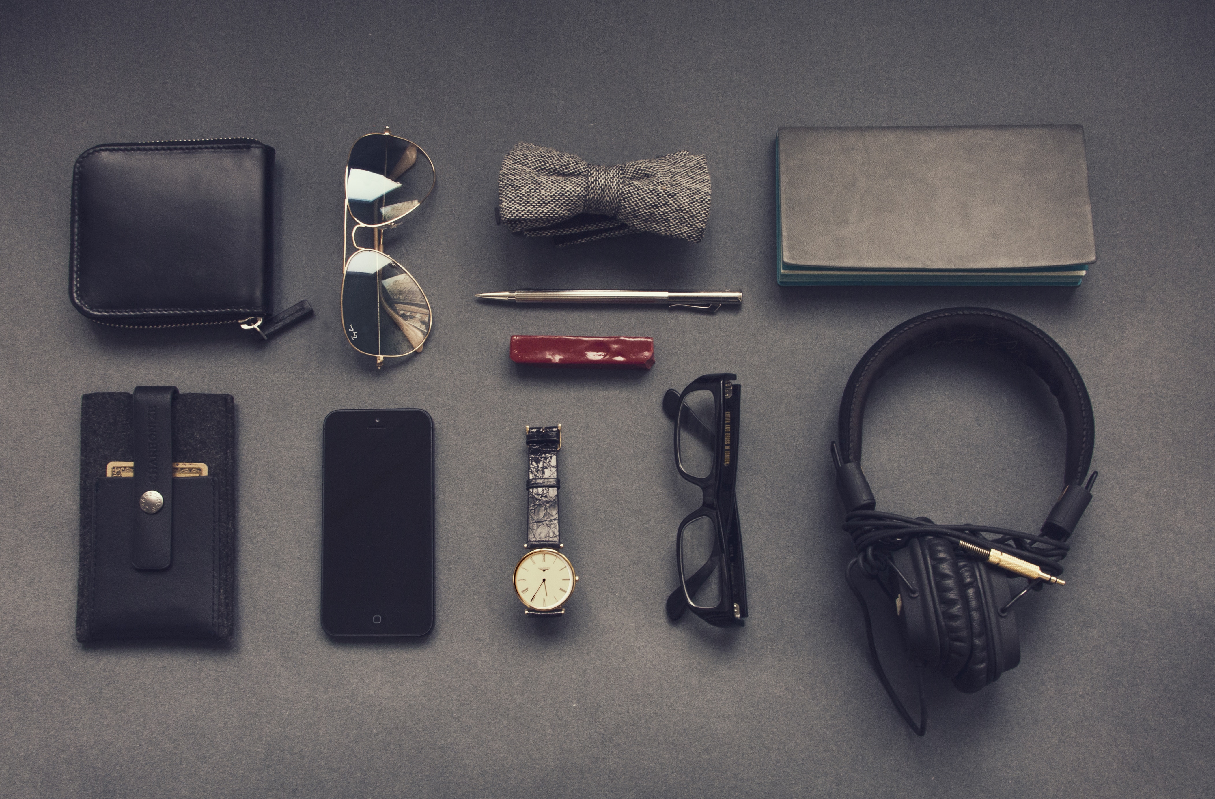 Flatlay of men's accessories including wallet, phone, and watch HD Wallpaper