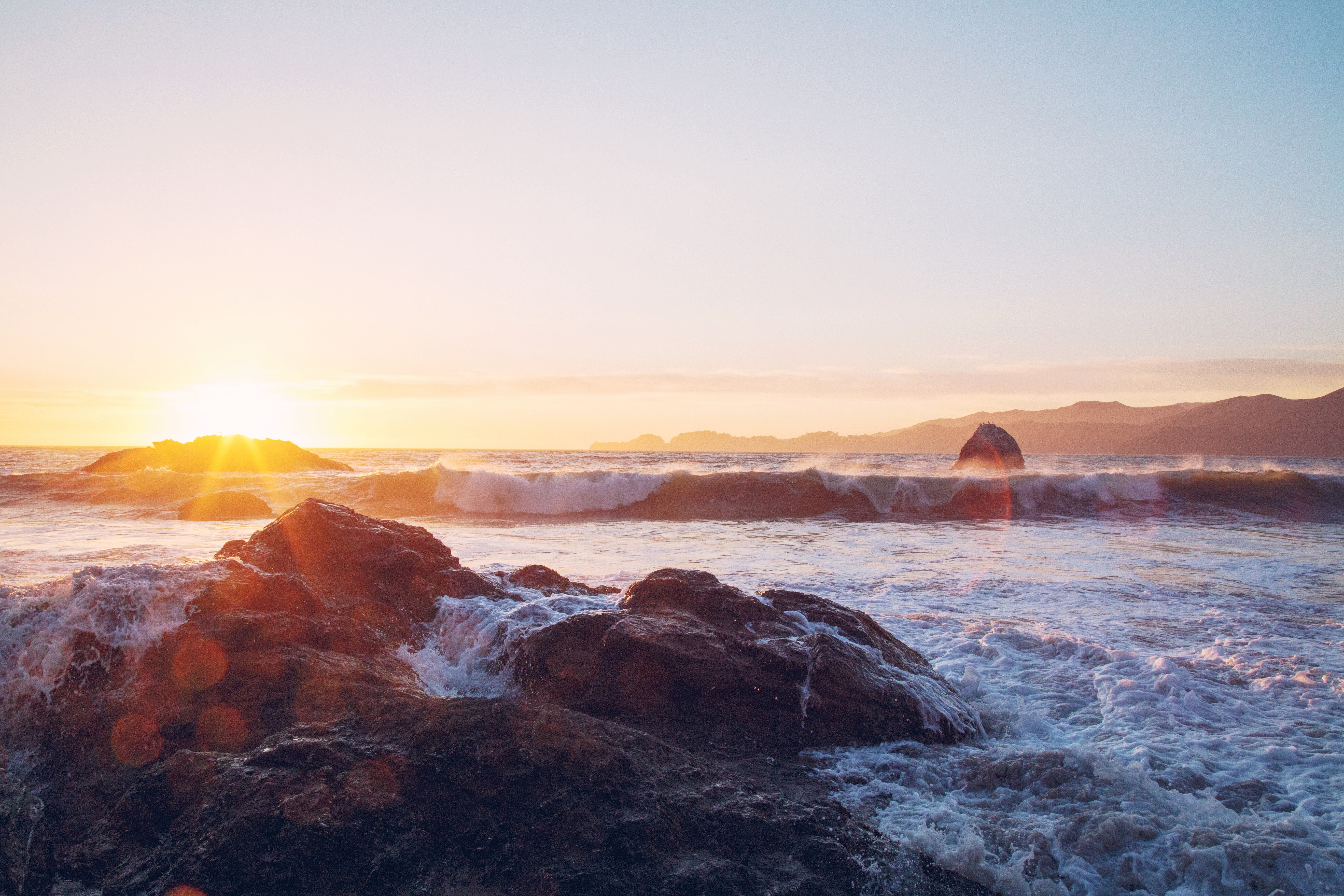 Ocean waves crash on rocks at sunrise HD Wallpaper