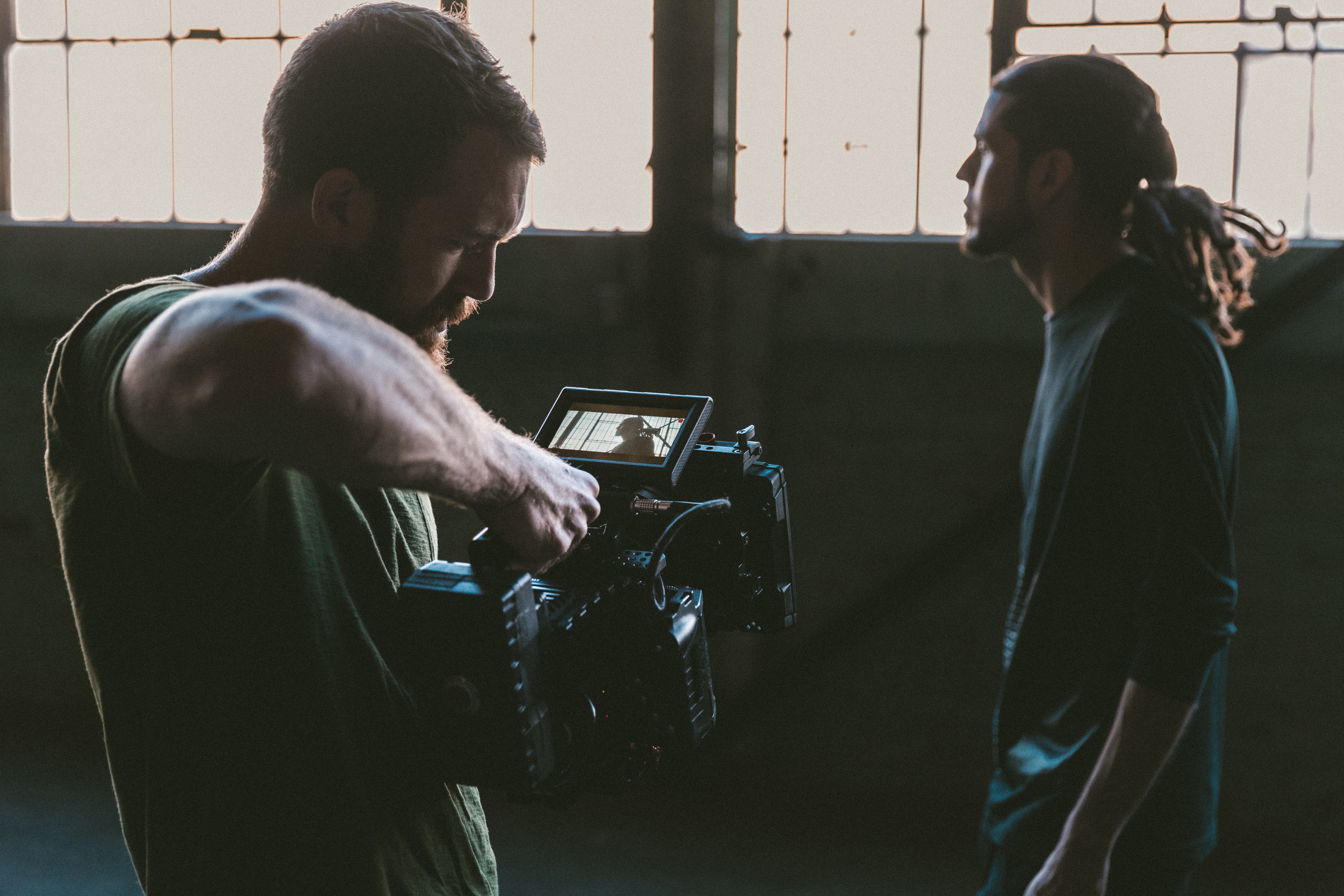 Man filming another man with a video camera HD Wallpaper
