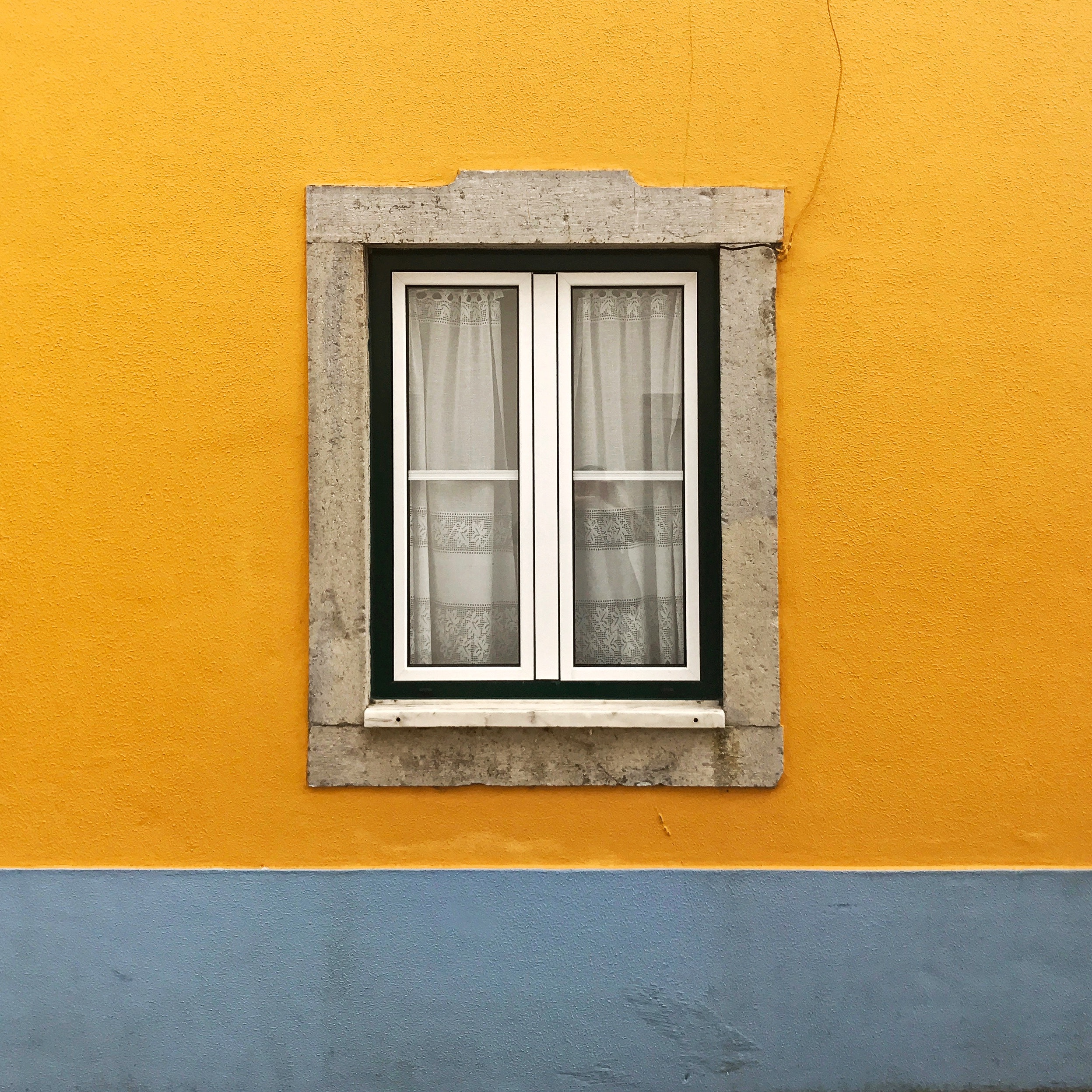 Yellow wall with a window and blue base HD Wallpaper
