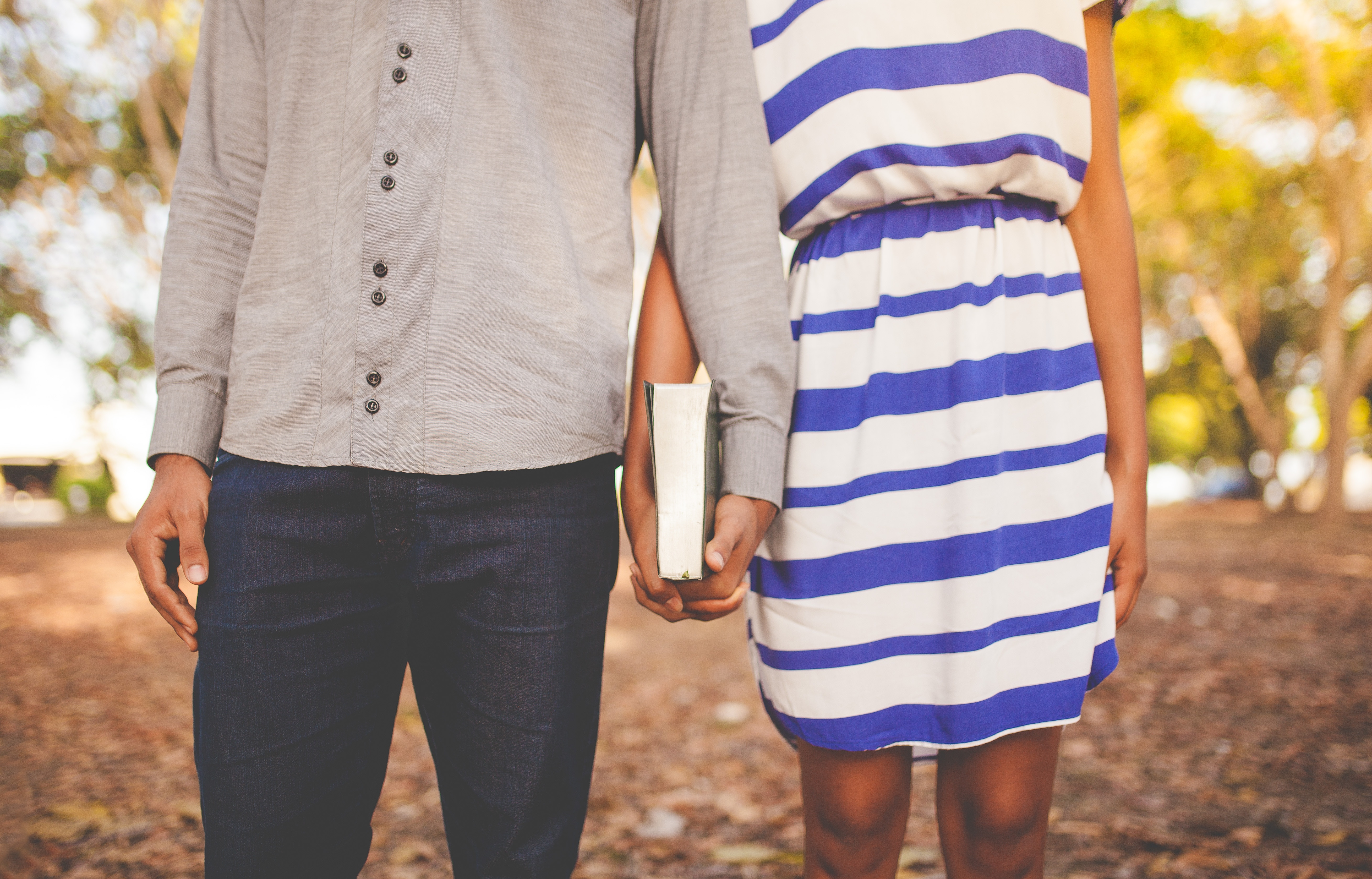Couple holding a book and hands outdoors HD Wallpaper