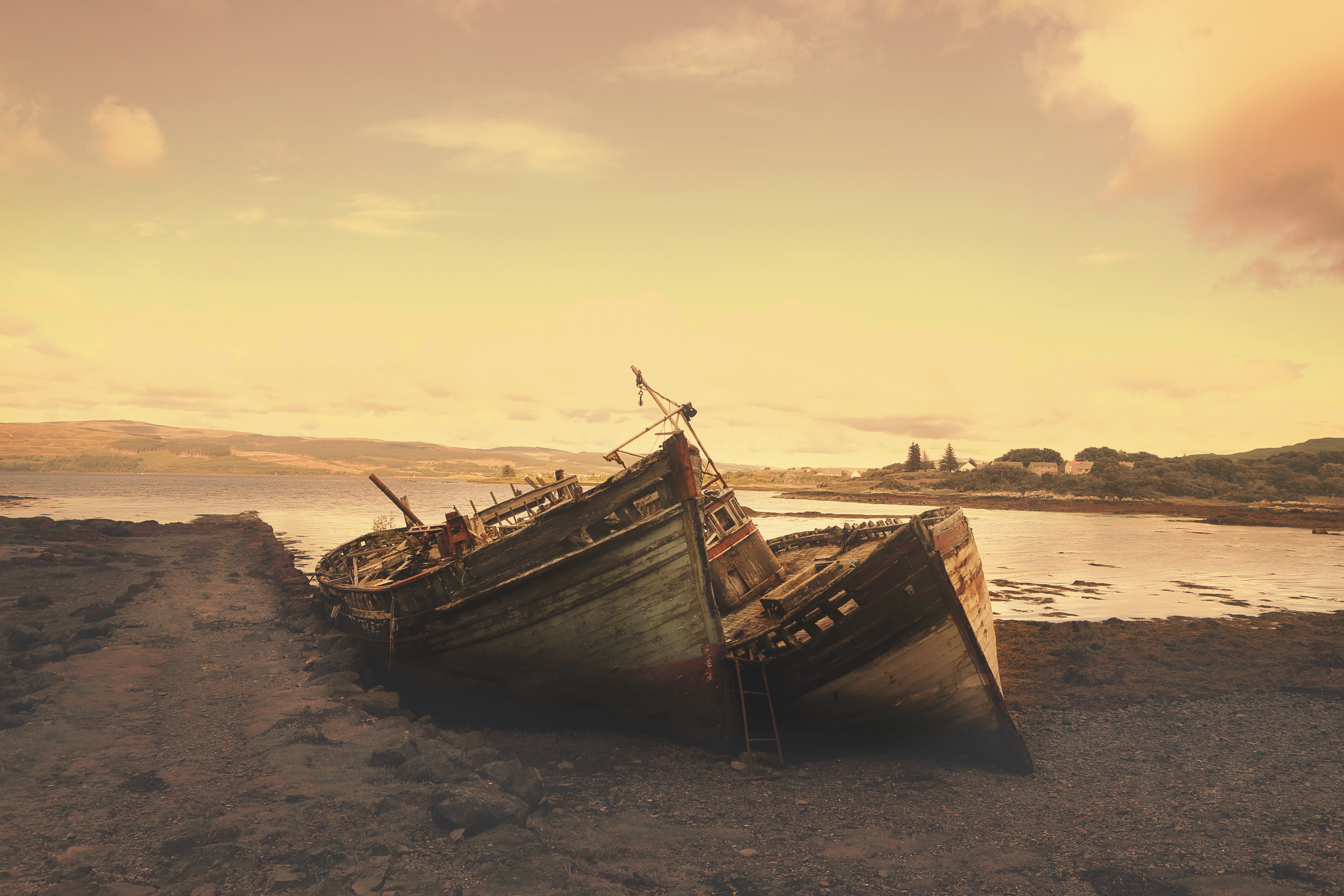 Abandoned Wooden Shipwreck on Rocky Shore at Sunset HD Wallpaper