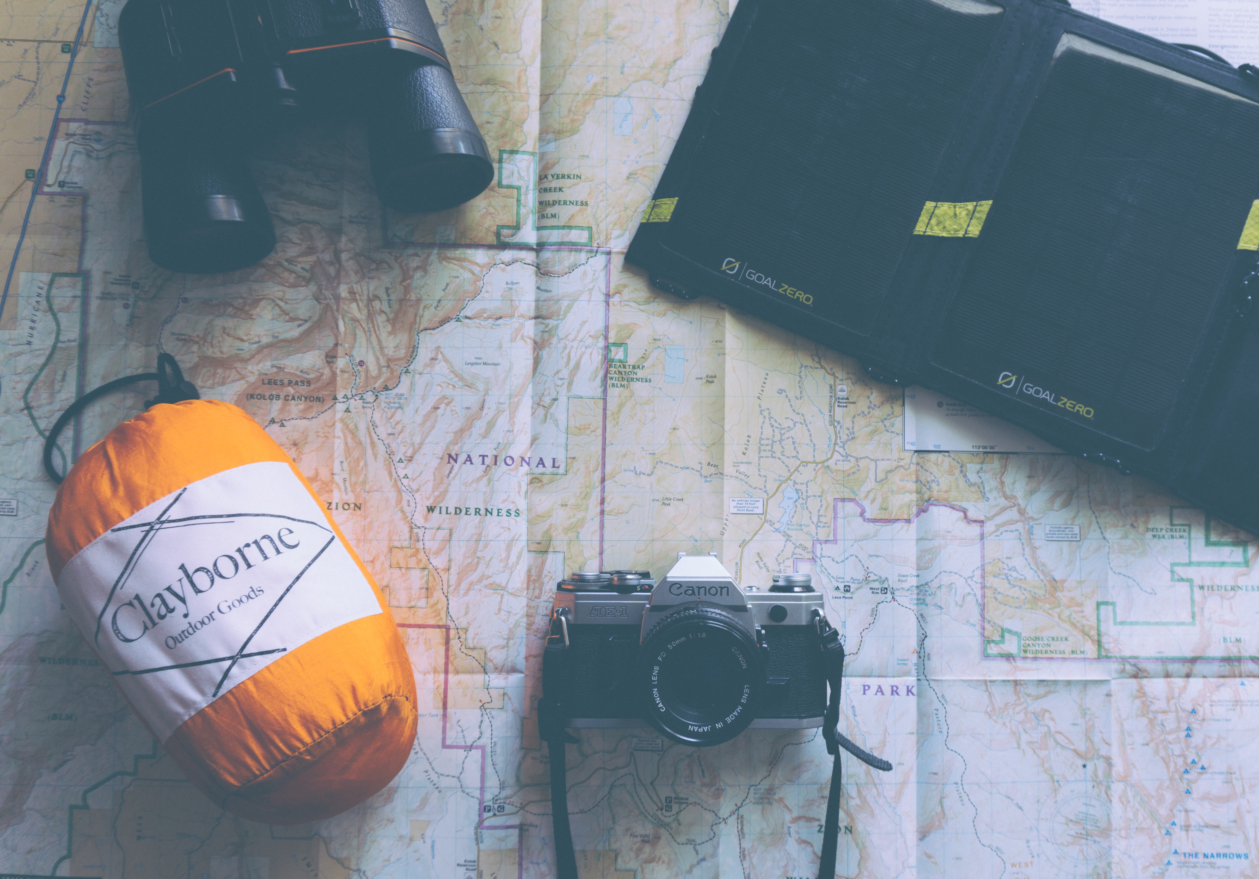 Overhead view of camping gear on a map HD Wallpaper