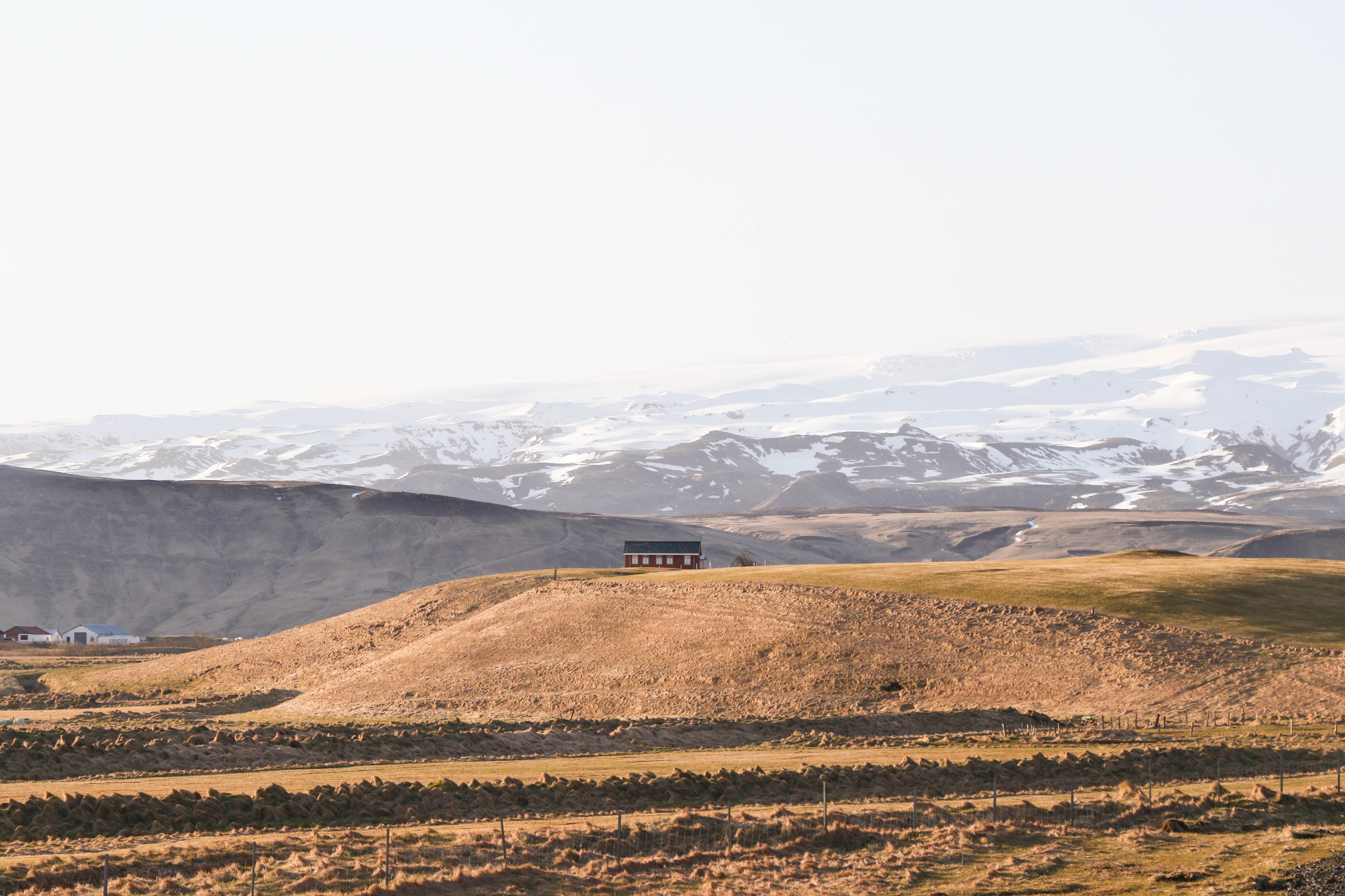 Red house on a hill in Iceland with snow-capped mountains HD Wallpaper