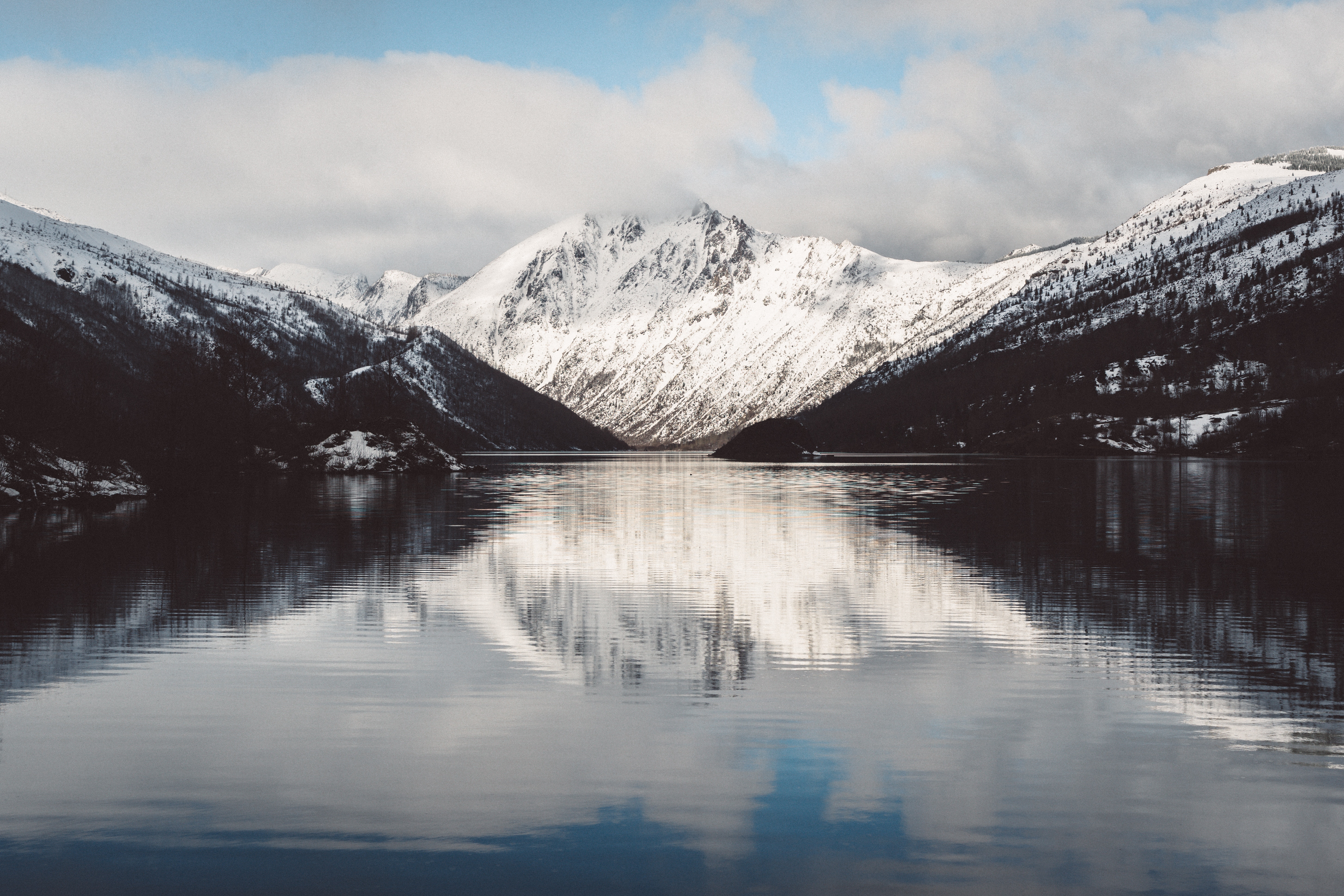 Snow-covered mountains reflected in a calm lake HD Wallpaper