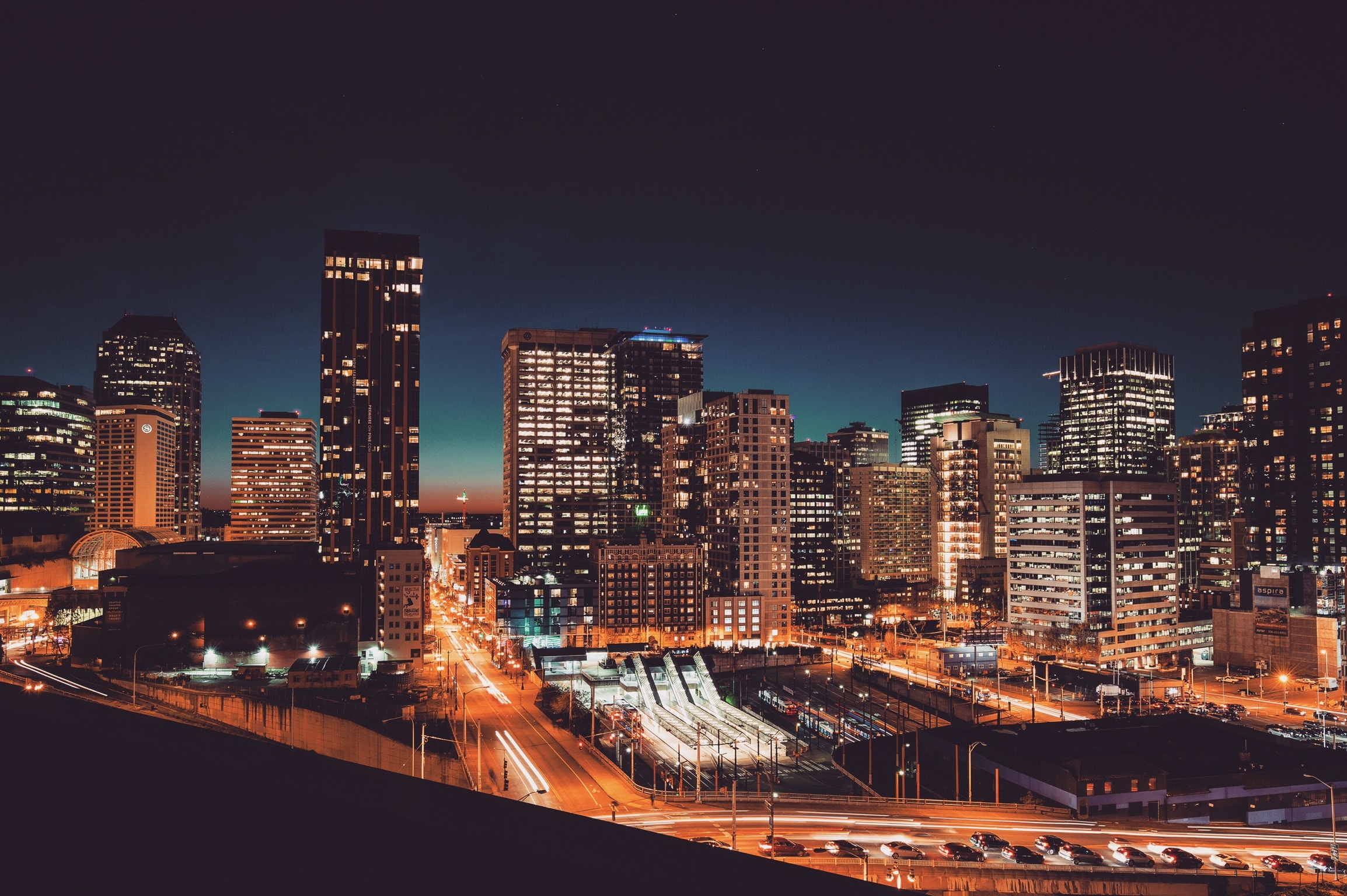 Cityscape at Night with Skyscrapers and Light Trails HD Wallpaper