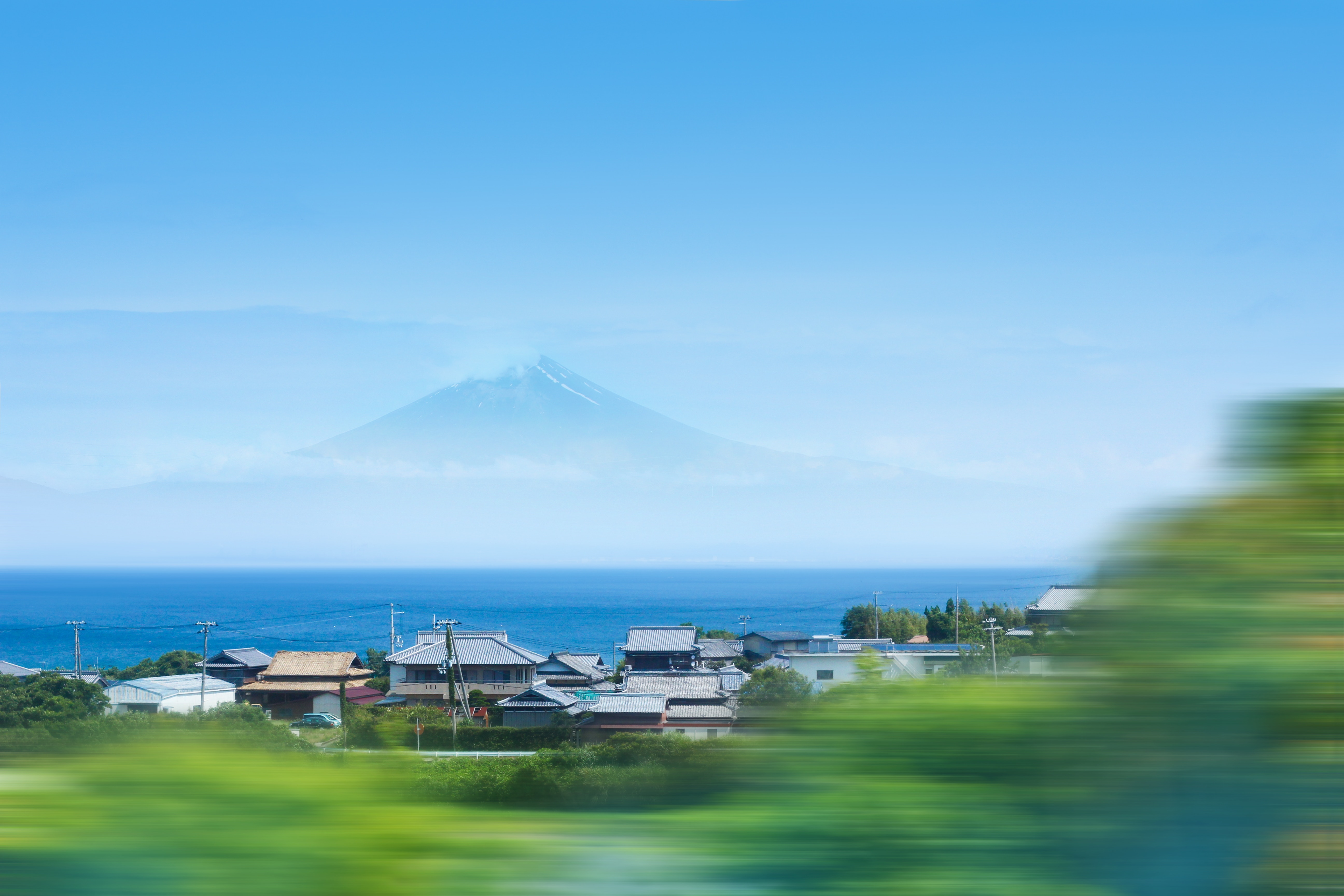 Mount Fuji over a coastal village in Japan HD Wallpaper