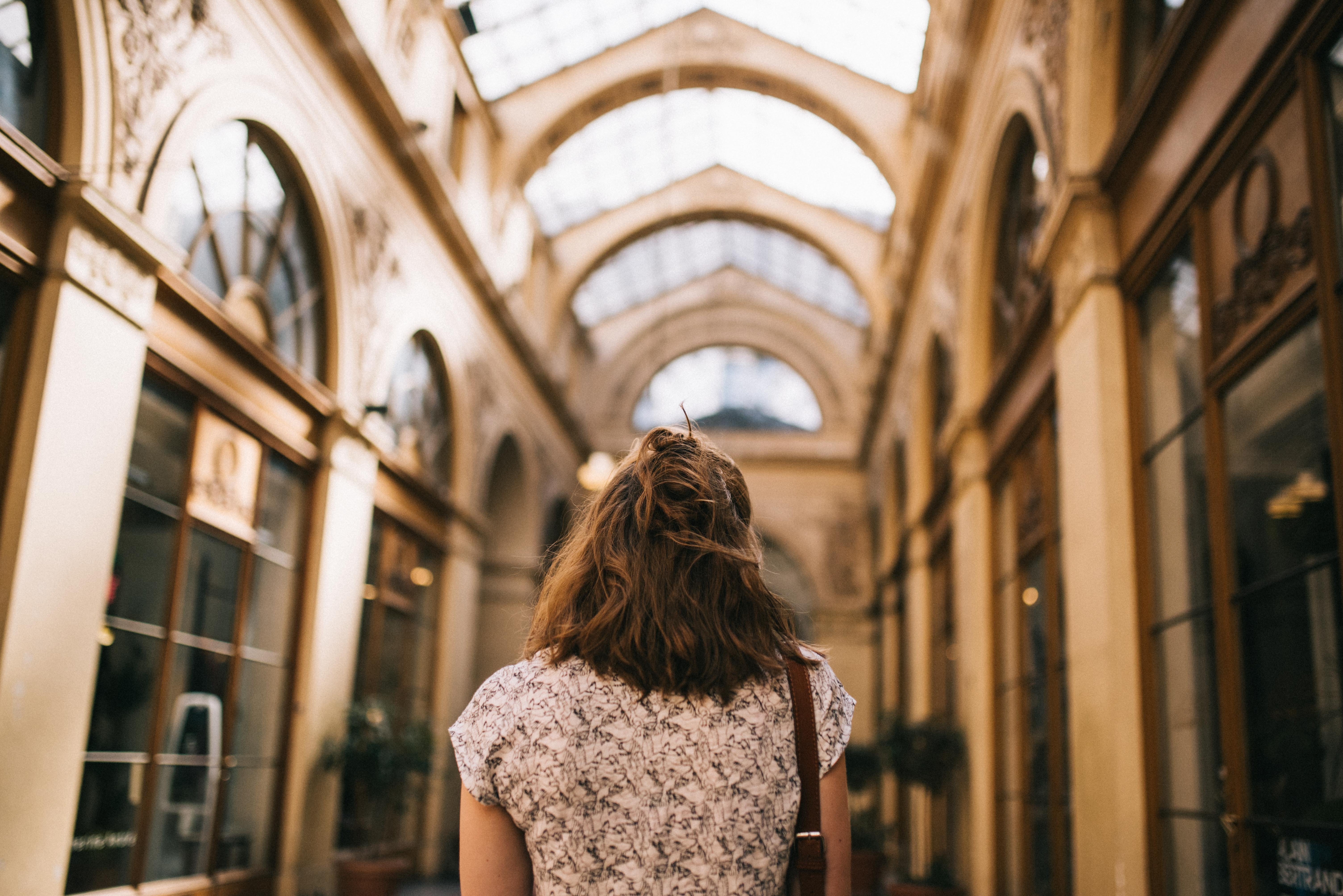 Woman walking through a Parisian gallery HD Wallpaper