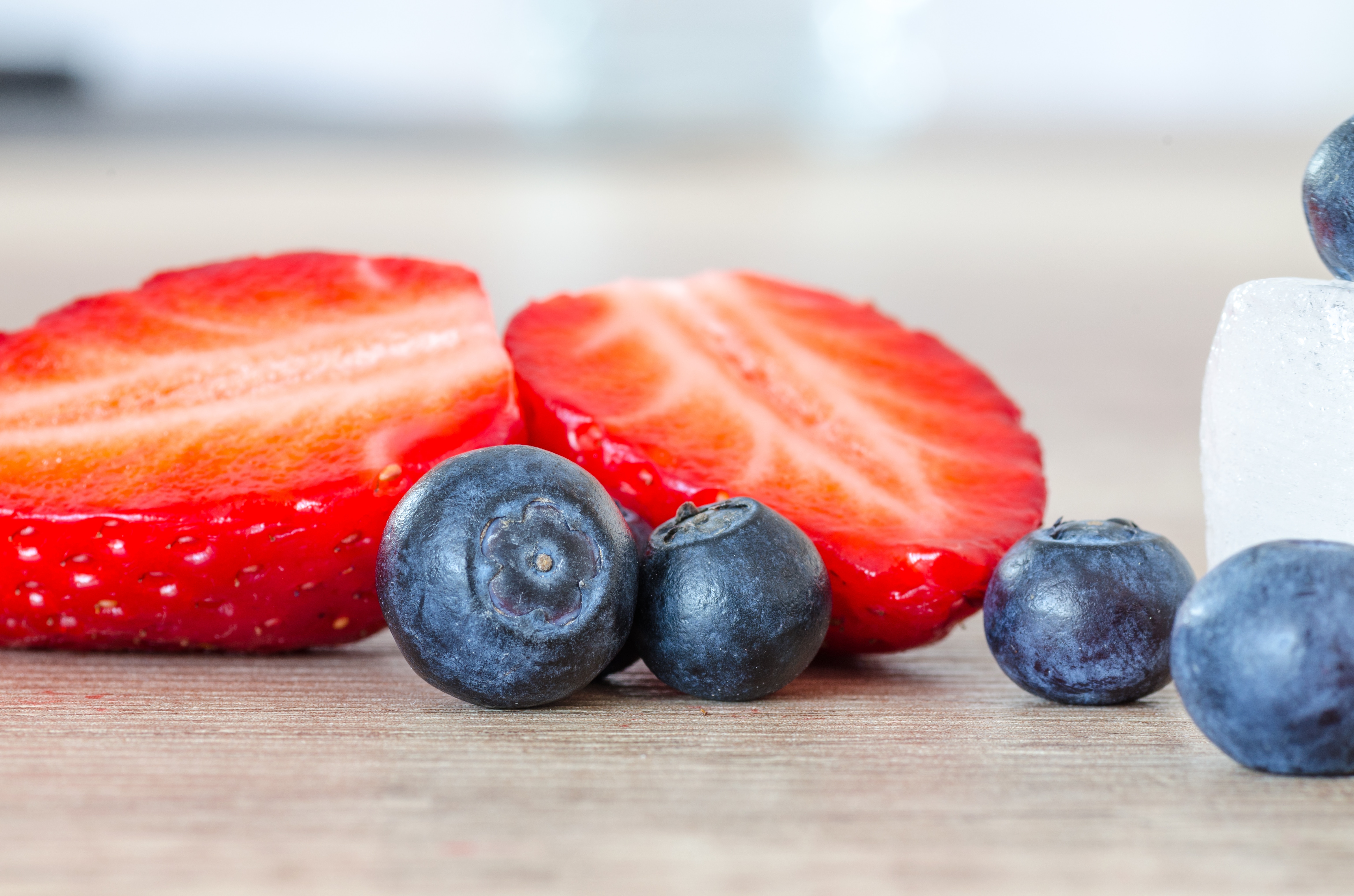 Blueberries and strawberries on a wooden surface HD Wallpaper