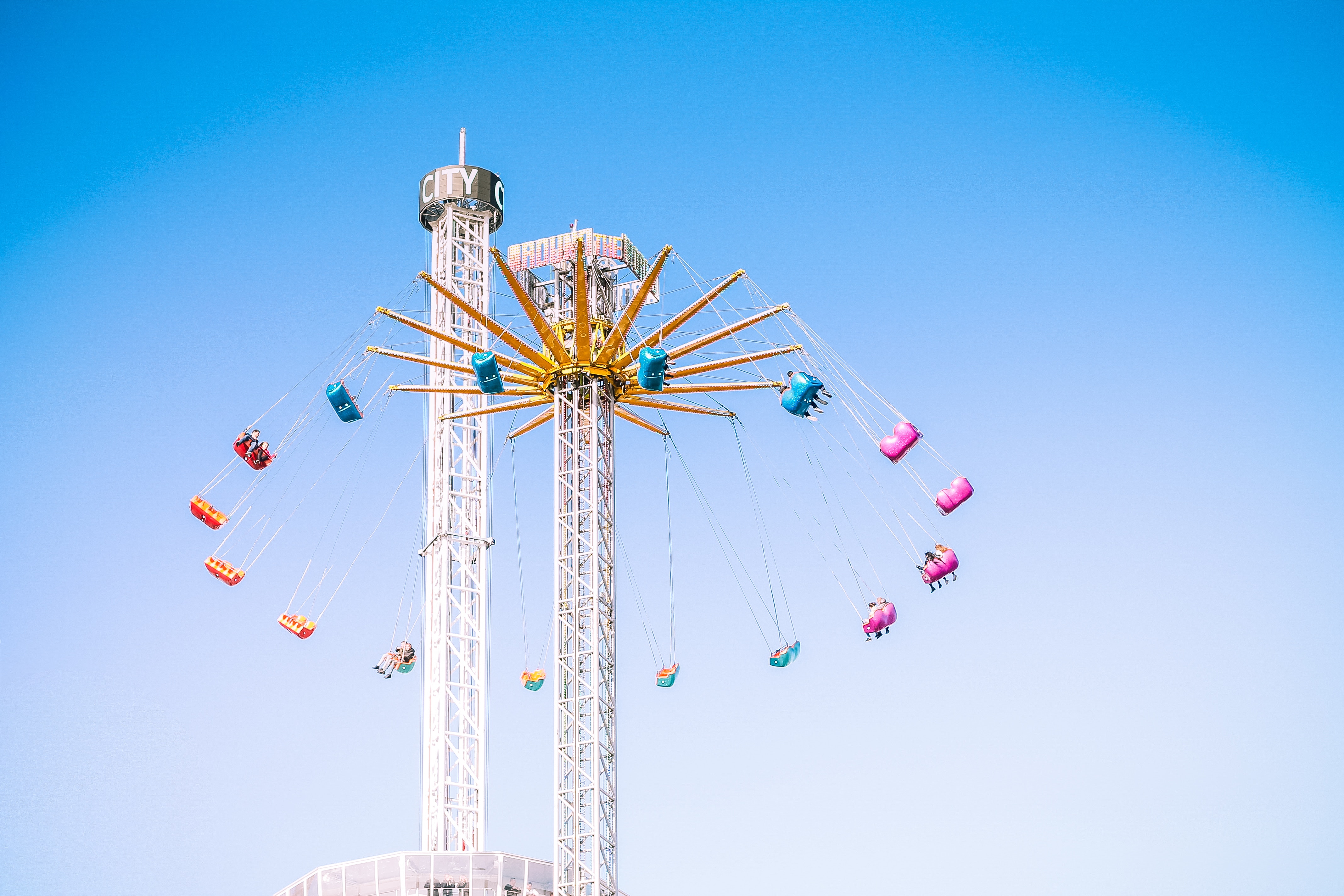 Amusement park swing ride against a clear blue sky HD Wallpaper
