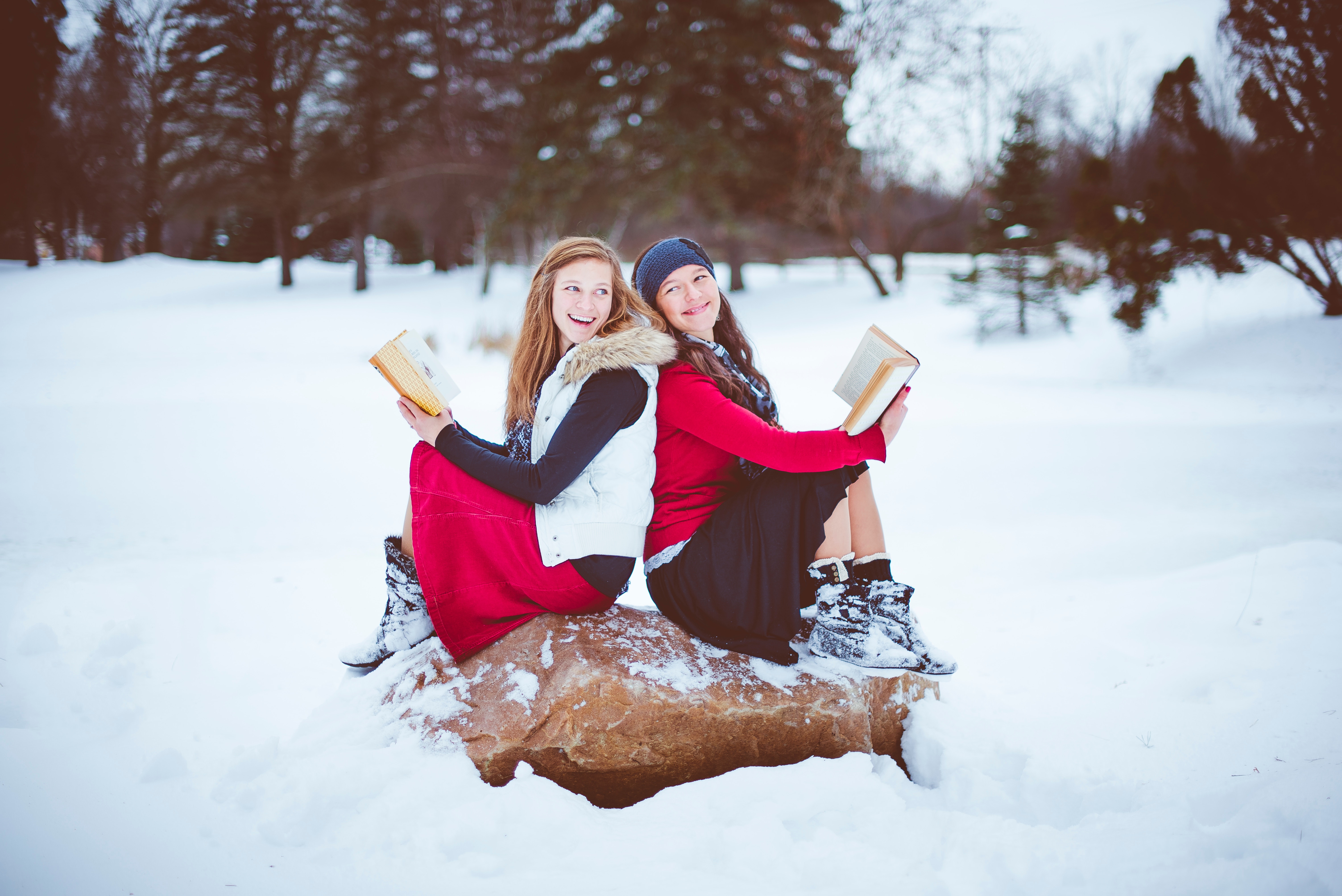 Two women reading books in the snow HD Wallpaper
