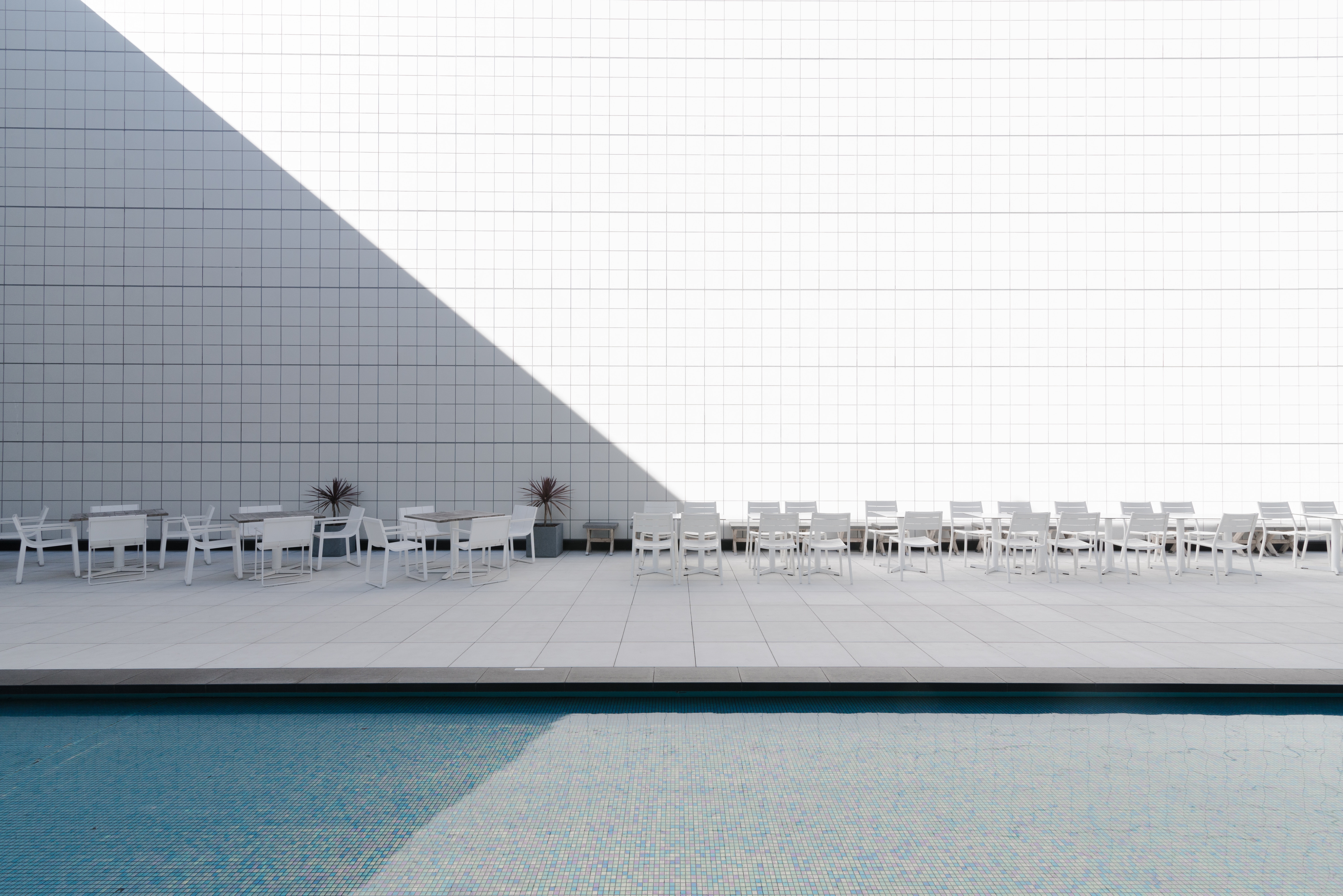 Minimalist patio with tables, chairs, and pool HD Wallpaper