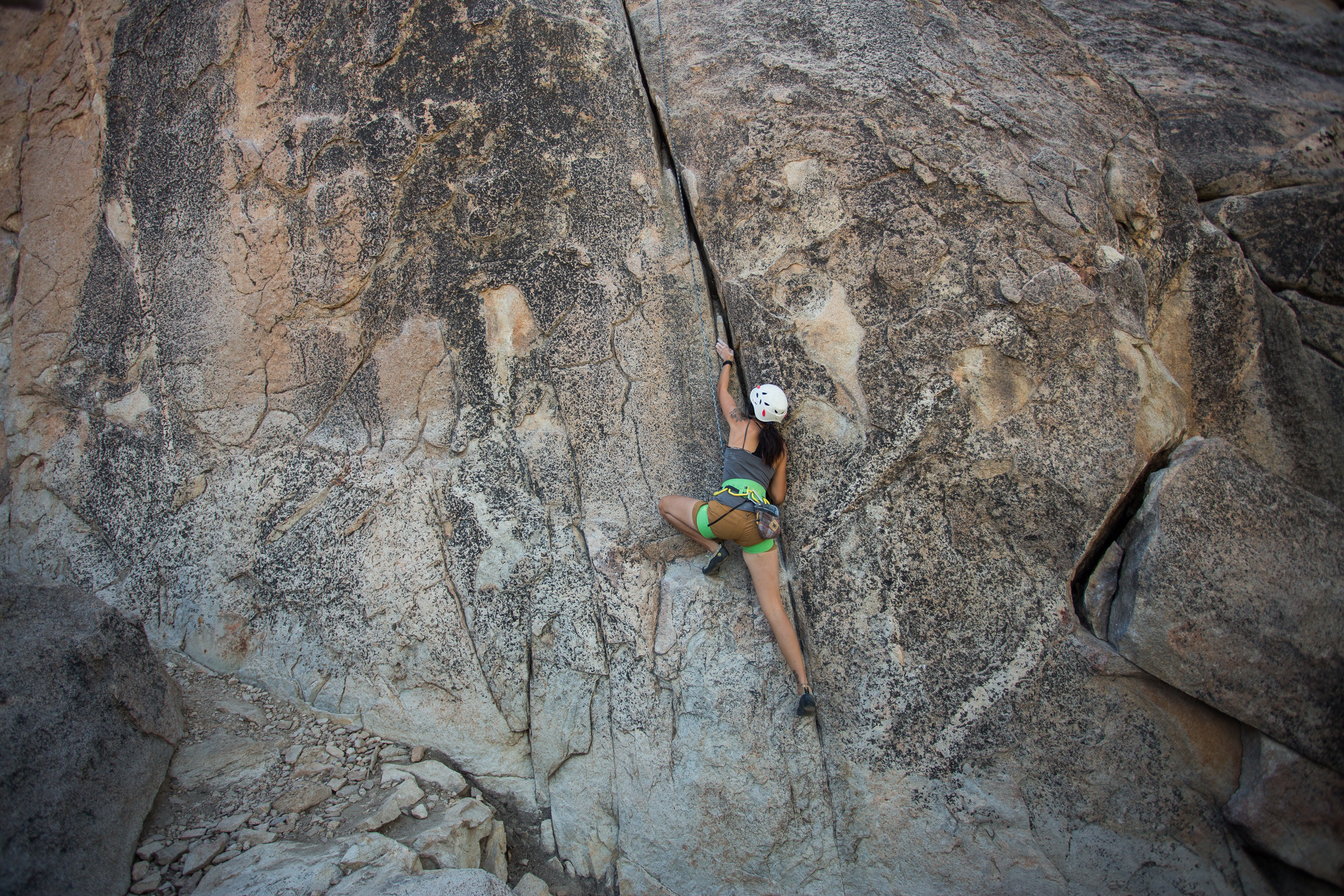 Woman climbing a rock face HD Wallpaper