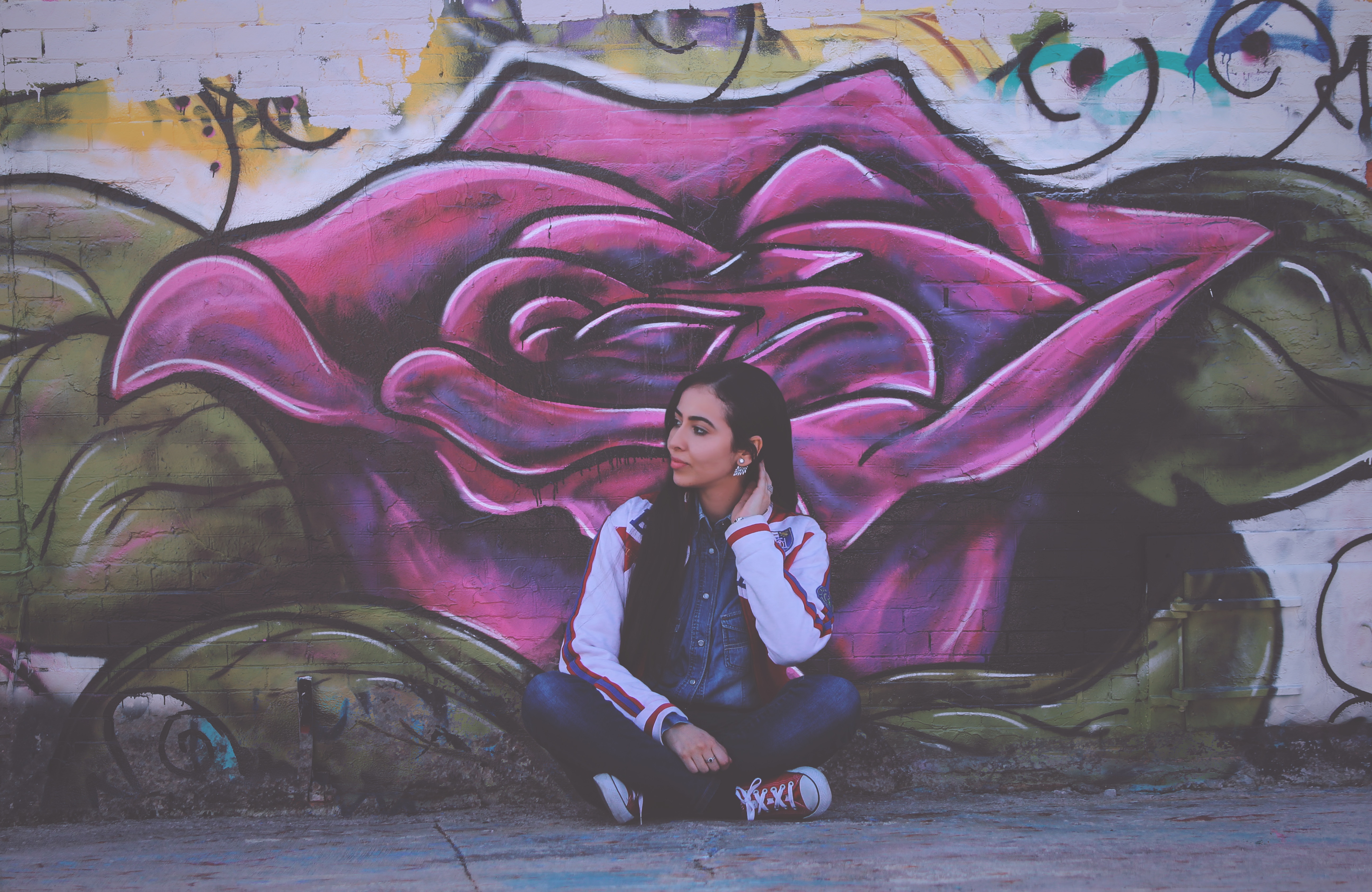 Woman sitting in front of a large rose graffiti HD Wallpaper