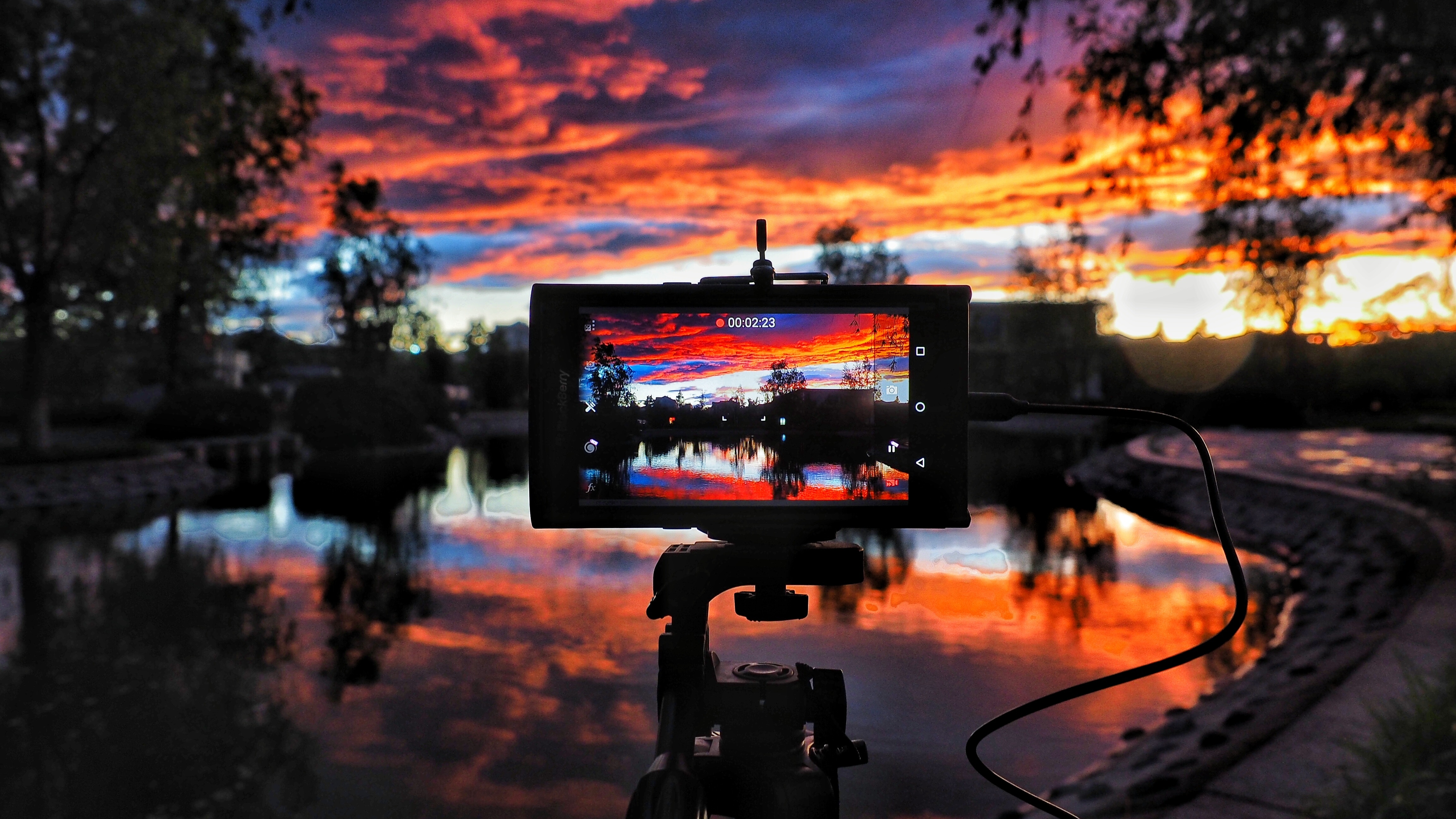 Camera recording a dramatic sunset over a lake HD Wallpaper