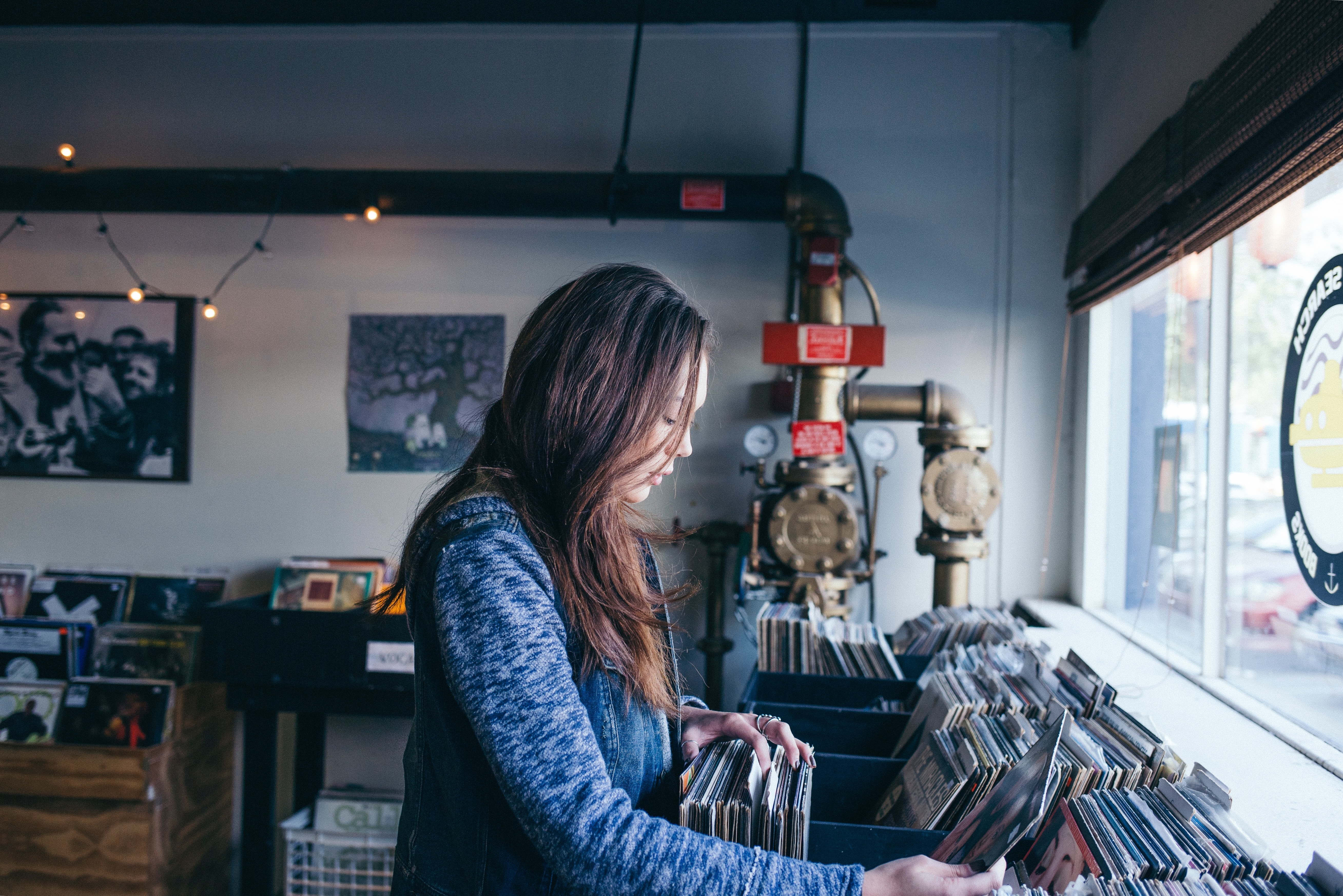 Woman browsing vinyl records in a store HD Wallpaper