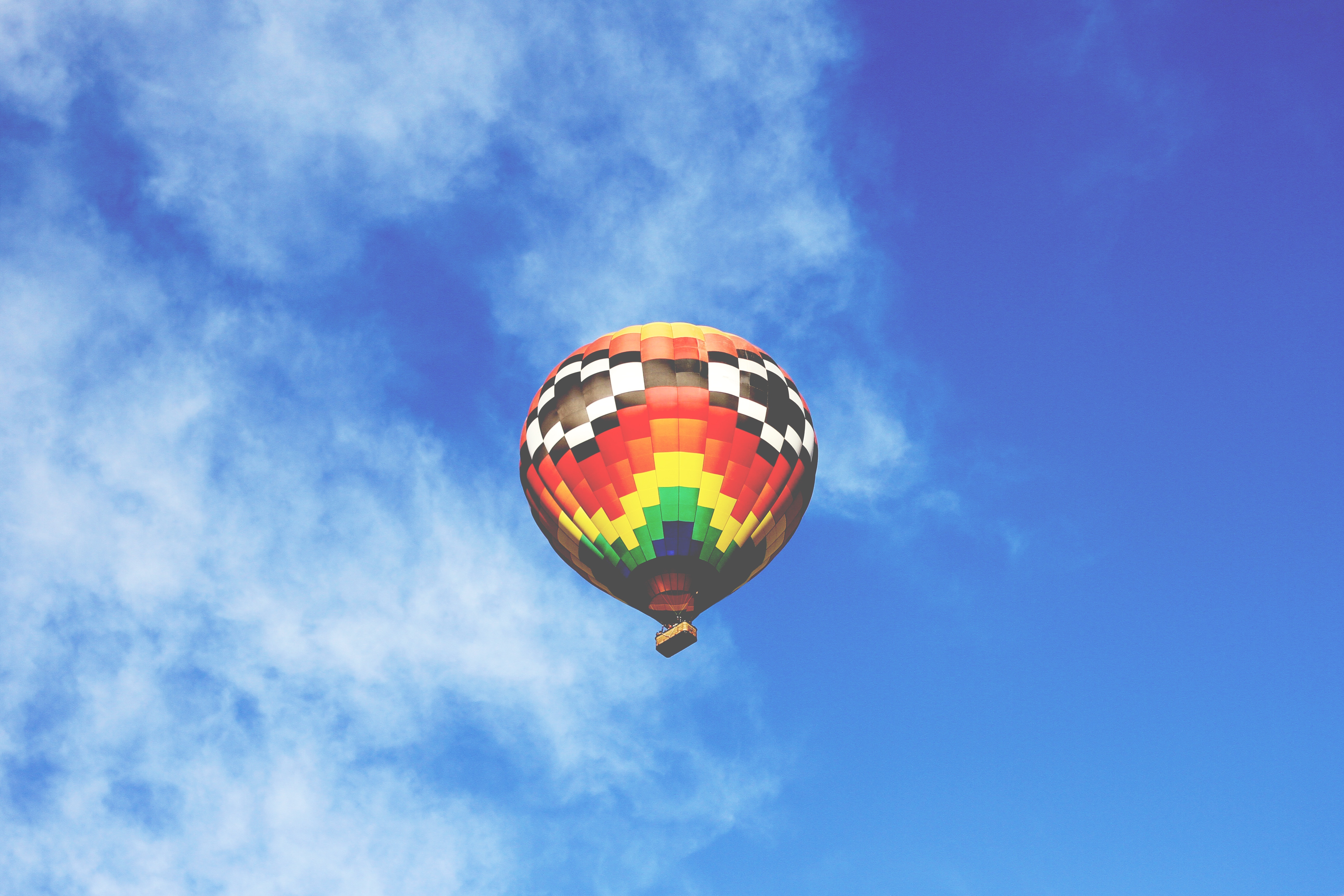 Colorful hot air balloon floating in a blue sky HD Wallpaper