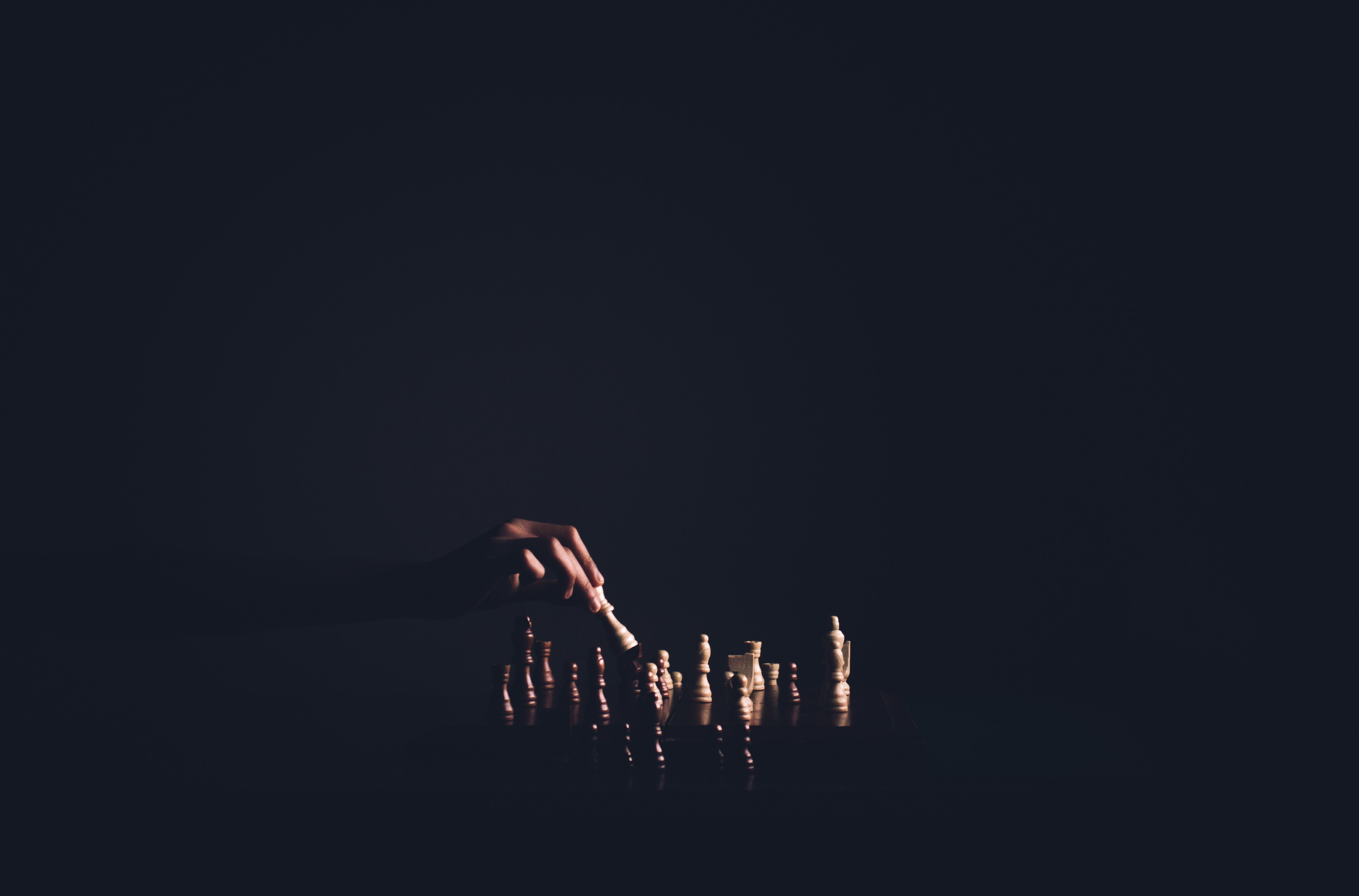 Hand moving chess piece in dark HD Wallpaper
