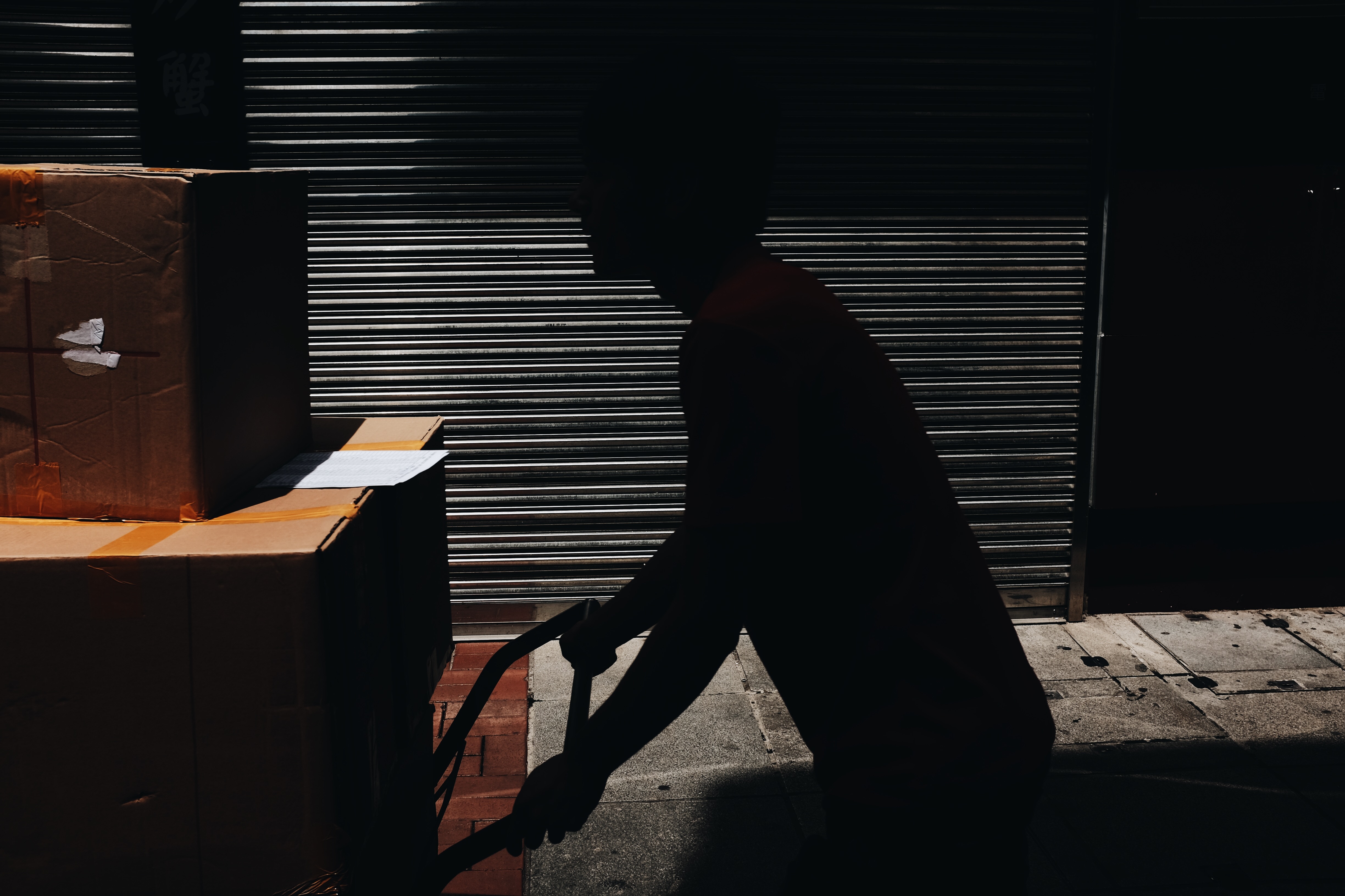 Man pushing boxes on a cart in Macau HD Wallpaper