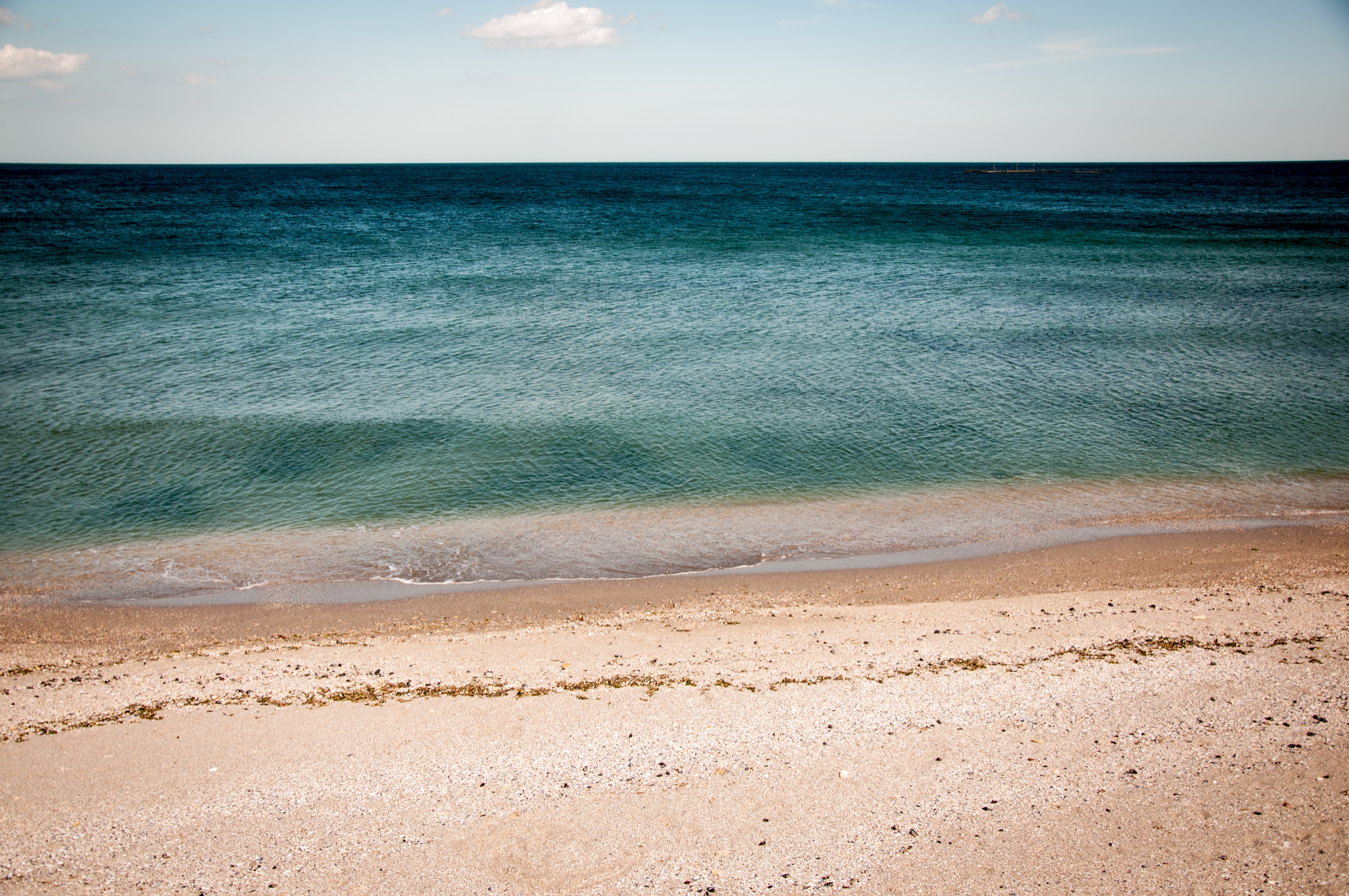 Ocean and sandy beach with a clear horizon HD Wallpaper