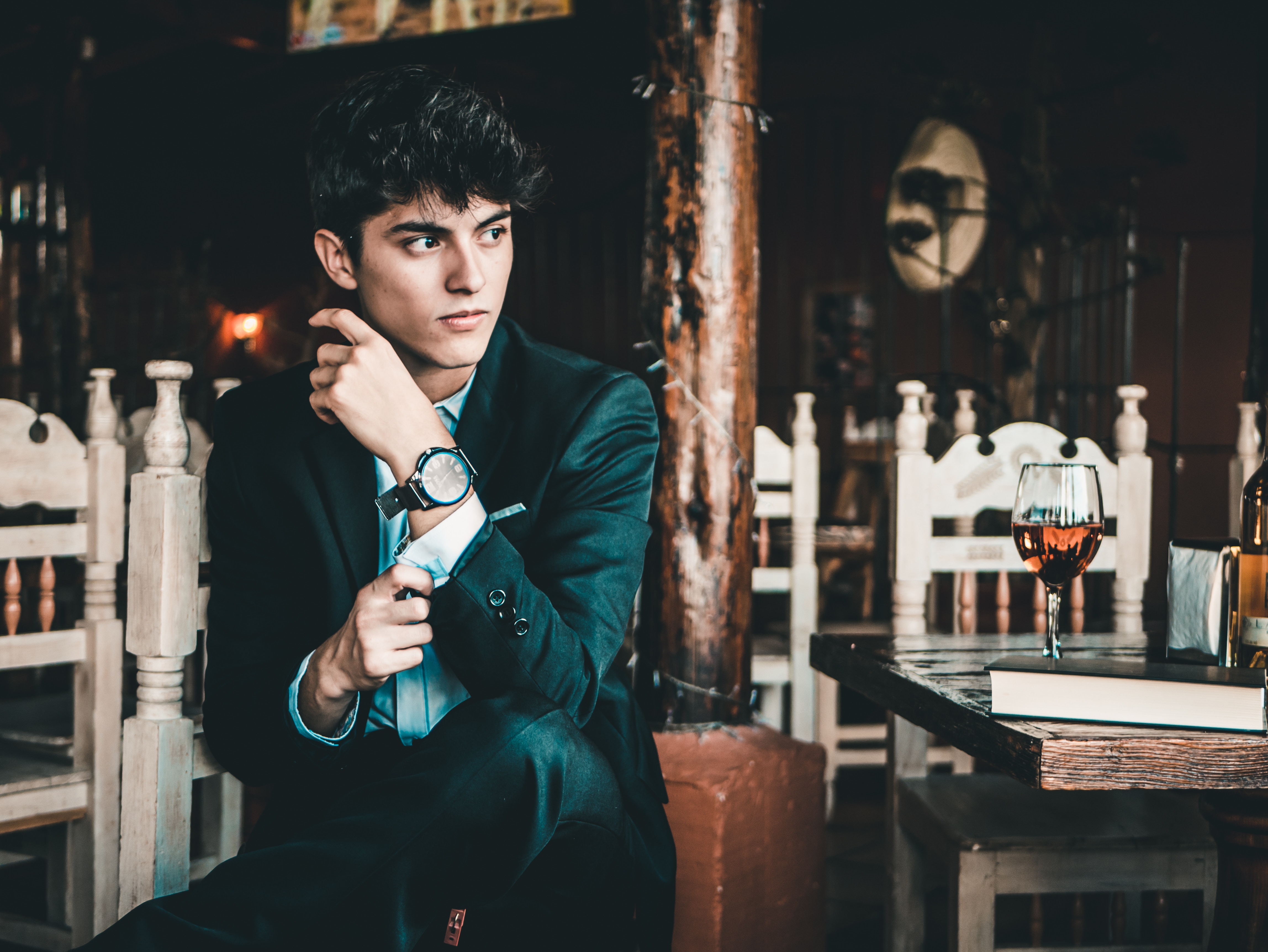 Man in suit adjusting cufflink in restaurant HD Wallpaper