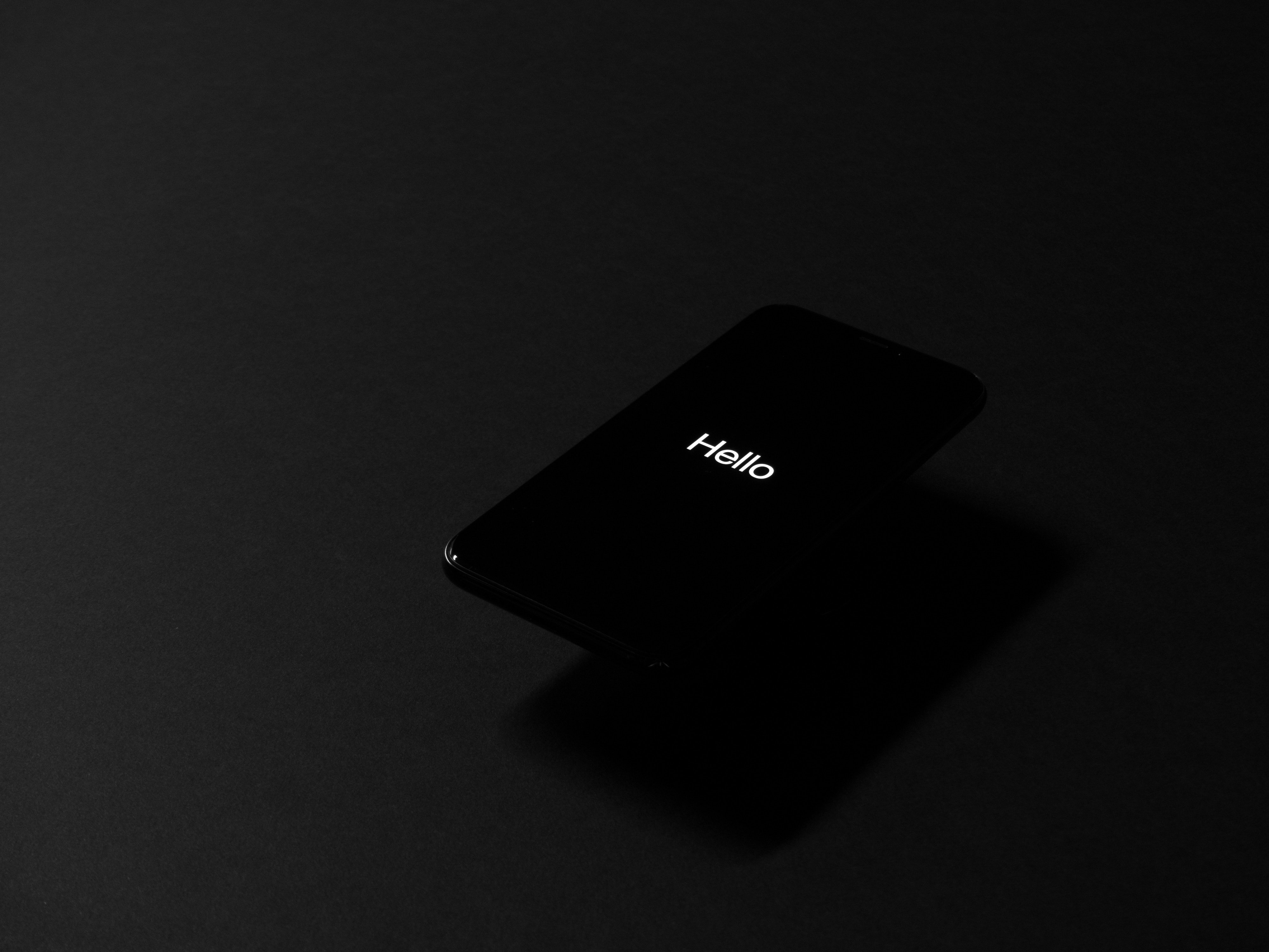 iPhone X with 'Hello' on screen in studio HD Wallpaper