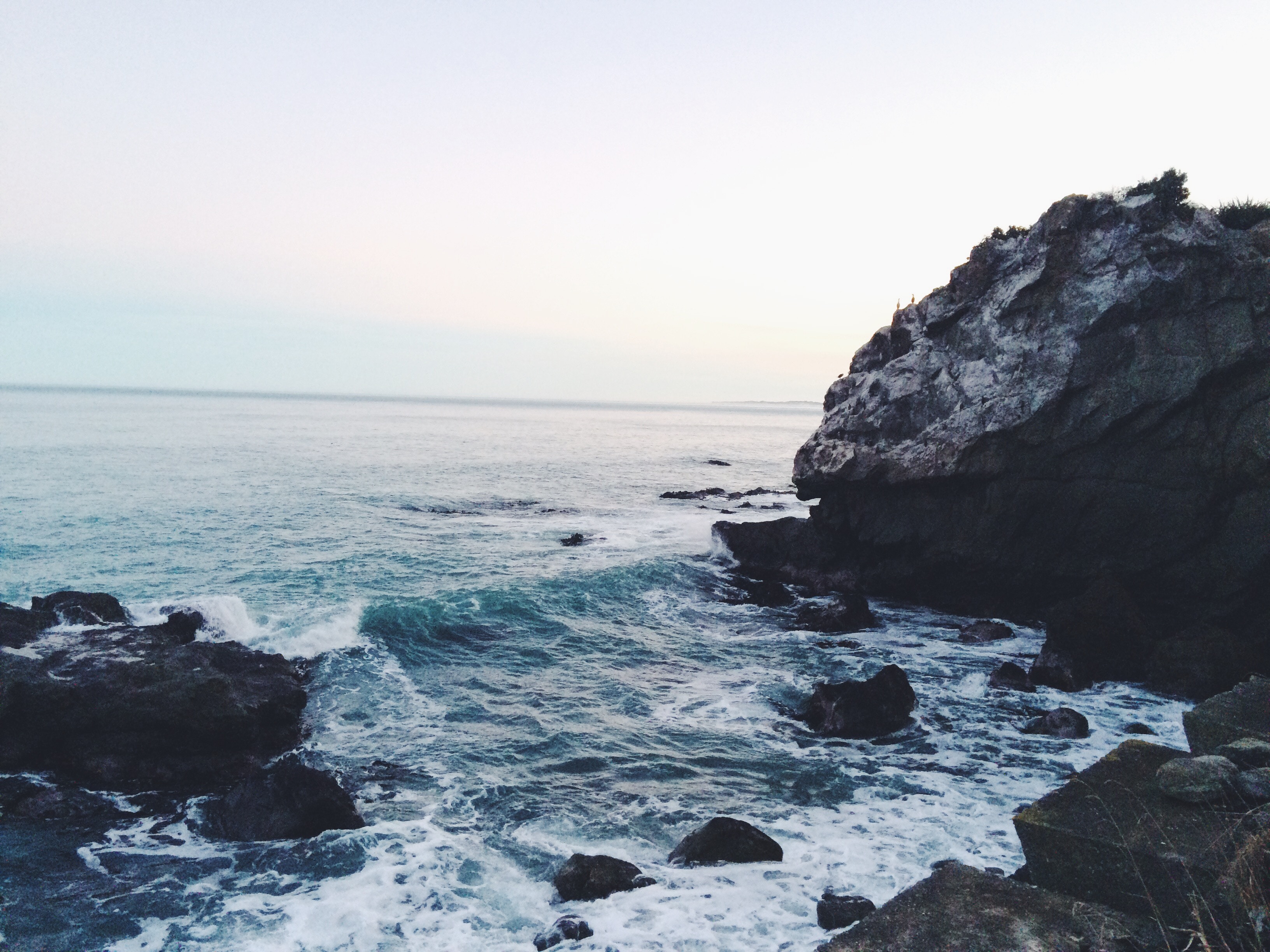 Rocky coast with waves crashing against rocks HD Wallpaper