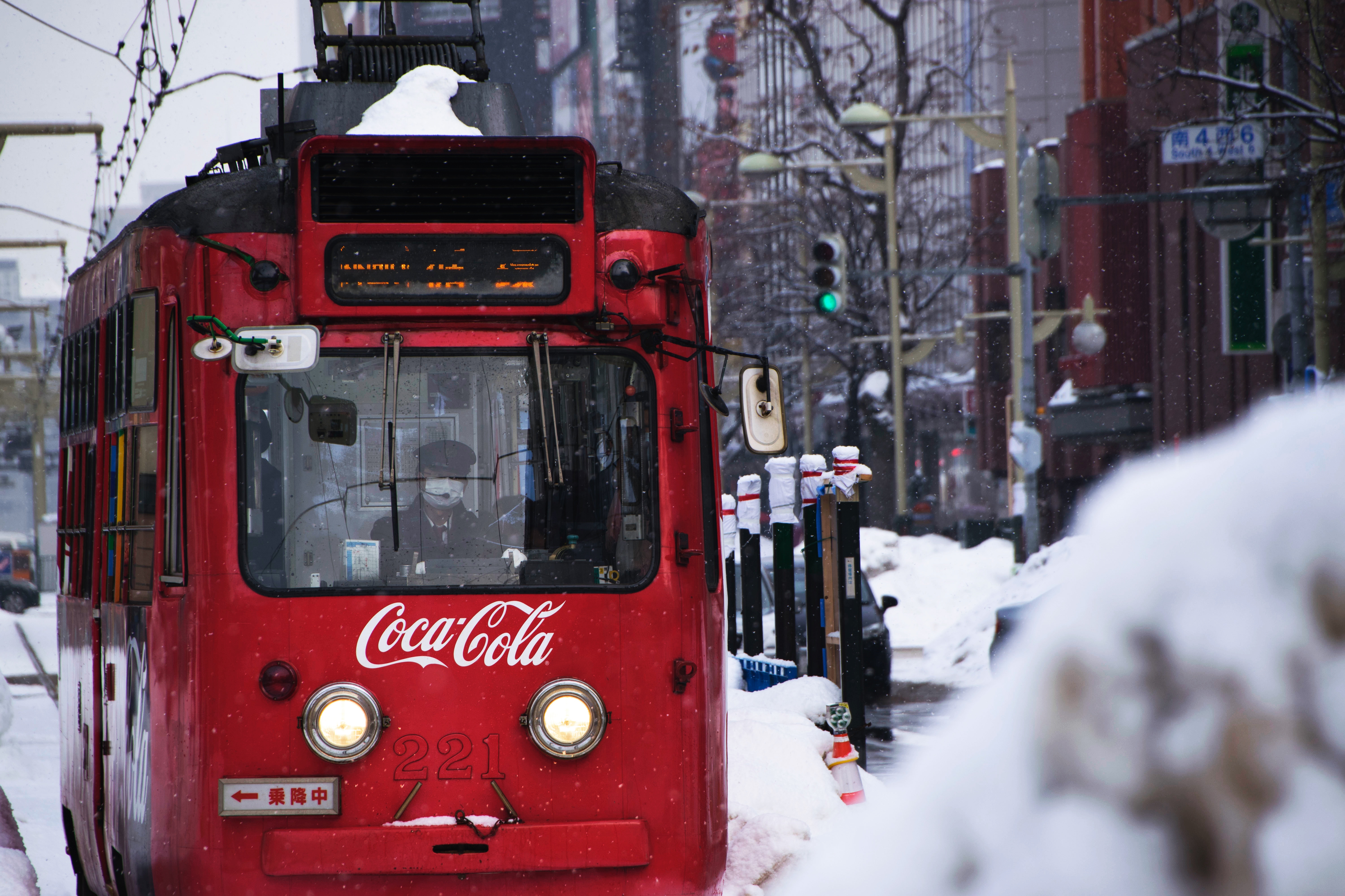 Red Coca-Cola tram number 221 in snowy city HD Wallpaper