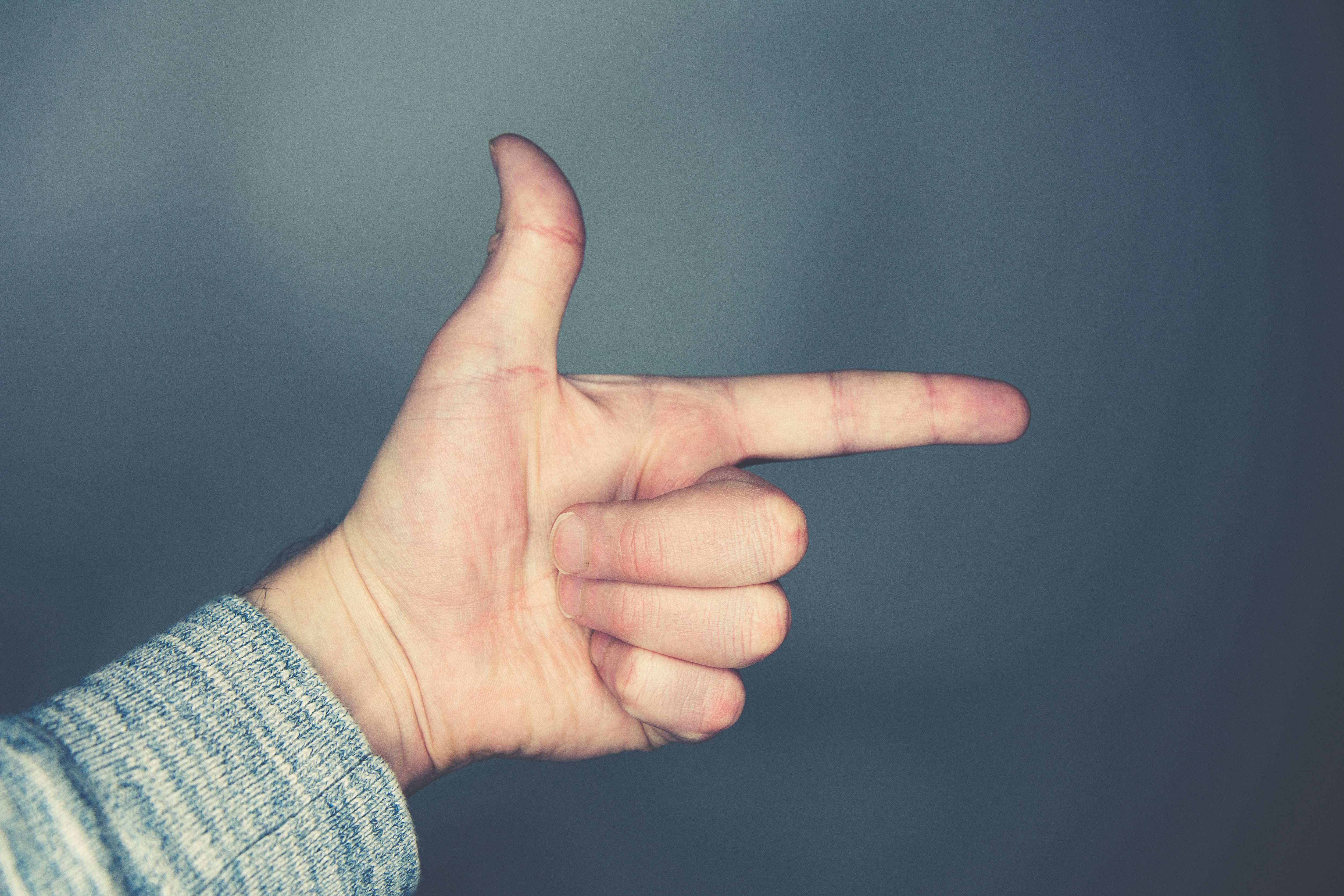 Hand pointing with thumb and index finger HD Wallpaper