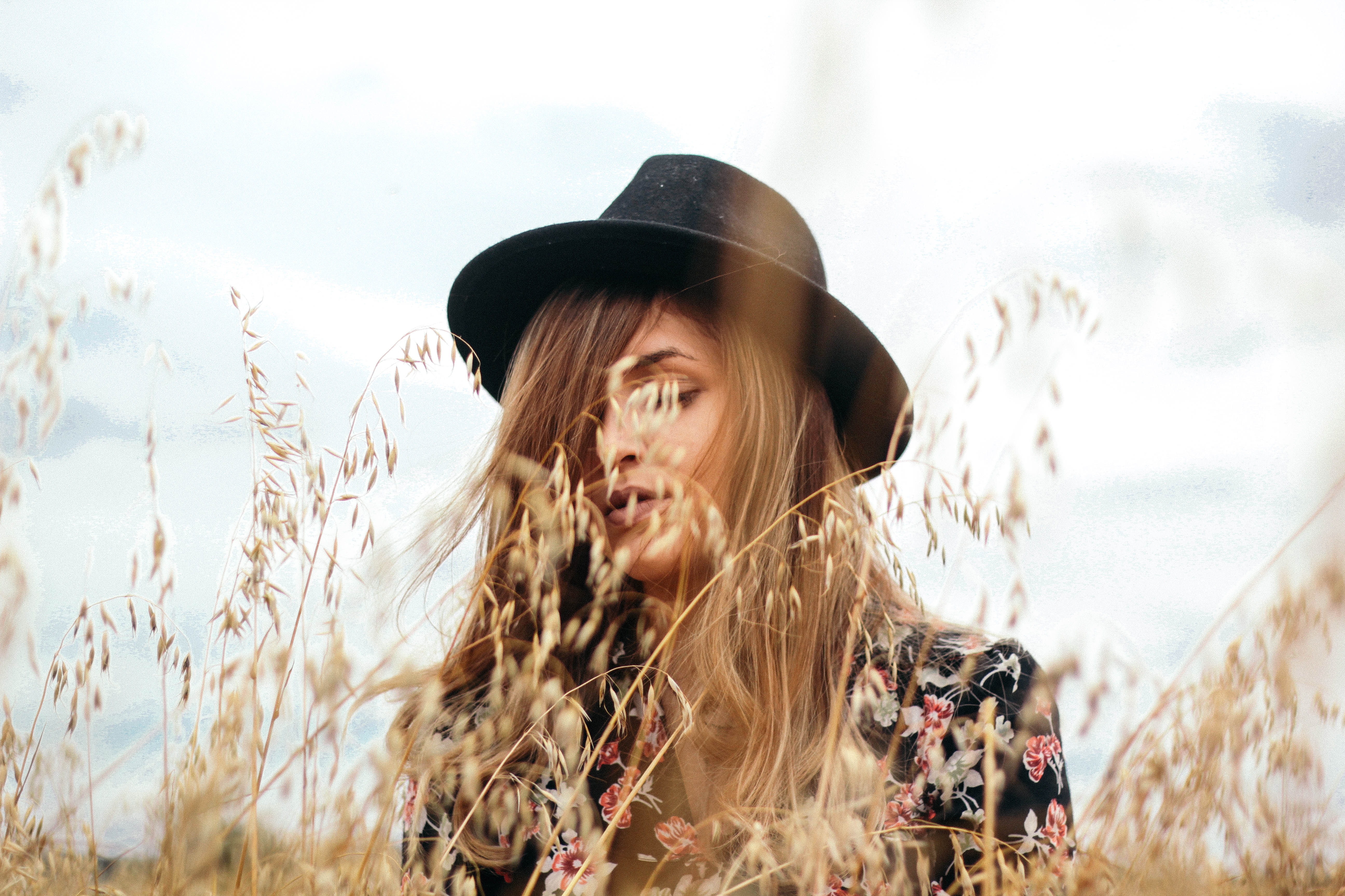 Woman in a floral shirt and hat in a wheat field HD Wallpaper