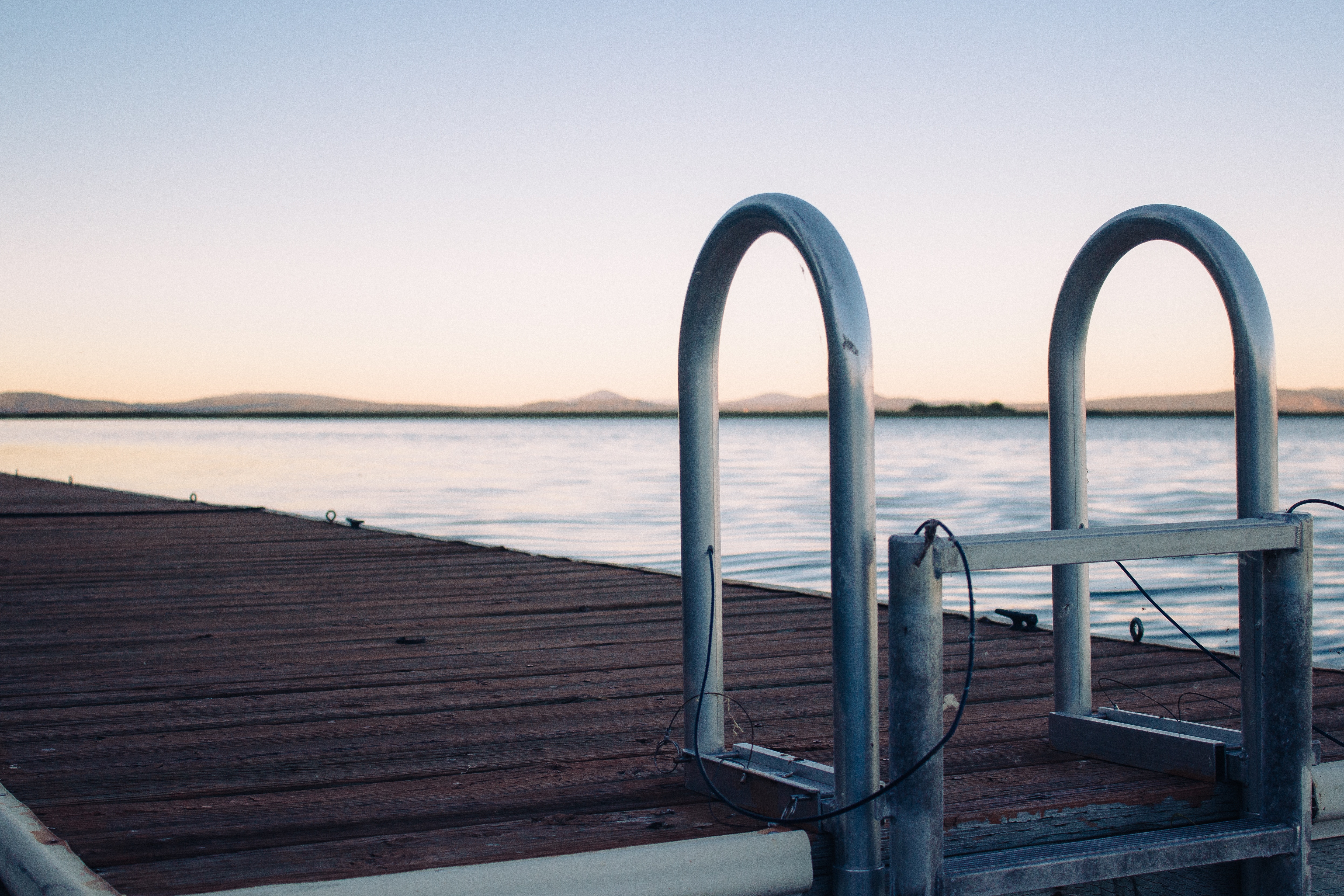 Dock ladder on a wooden pier at sunset HD Wallpaper