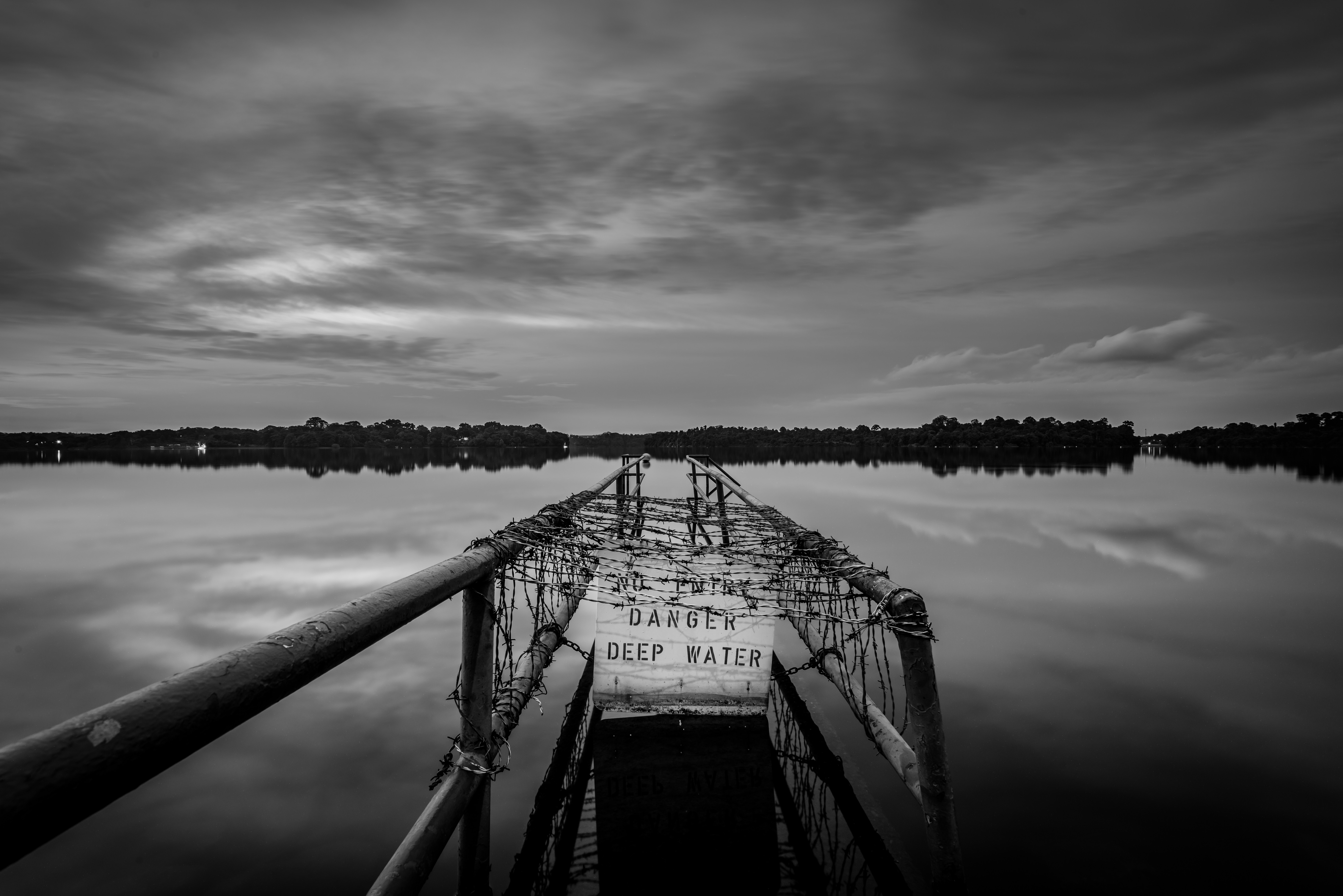 Monochrome pier with danger deep water sign over lake HD Wallpaper
