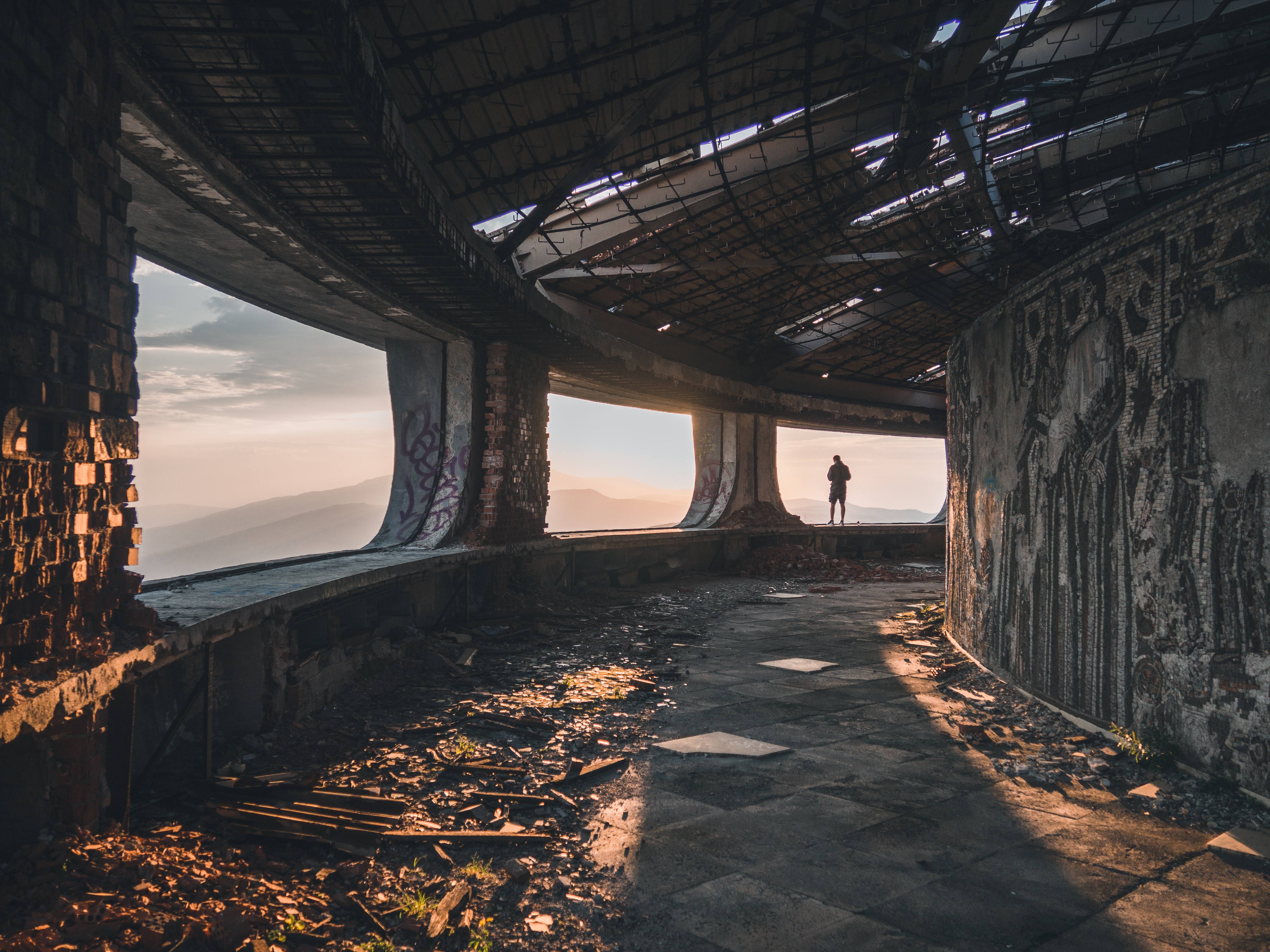 Buzludzha Monument interior with a person overlooking mountains HD Wallpaper