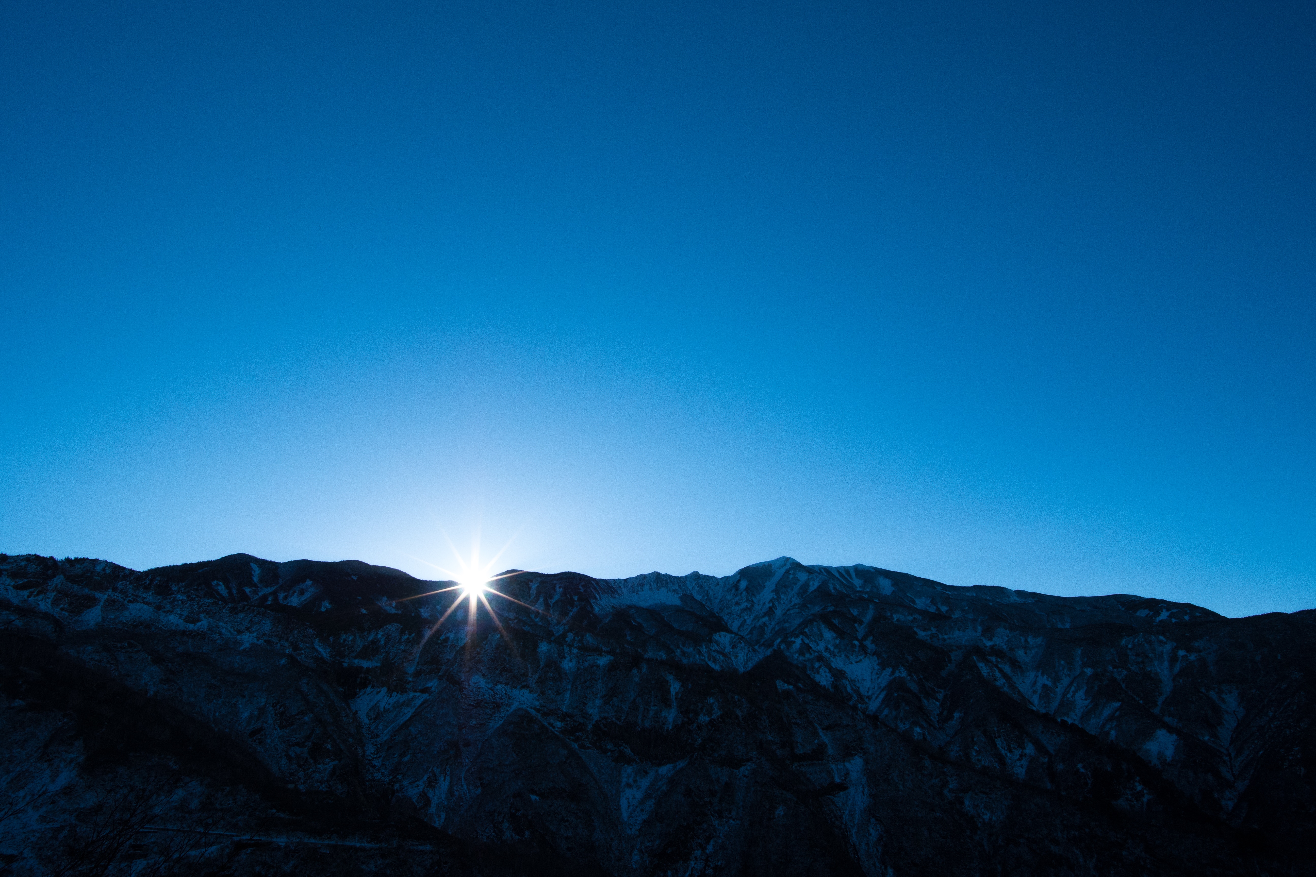 Sunrise over a snow-dusted mountain range HD Wallpaper