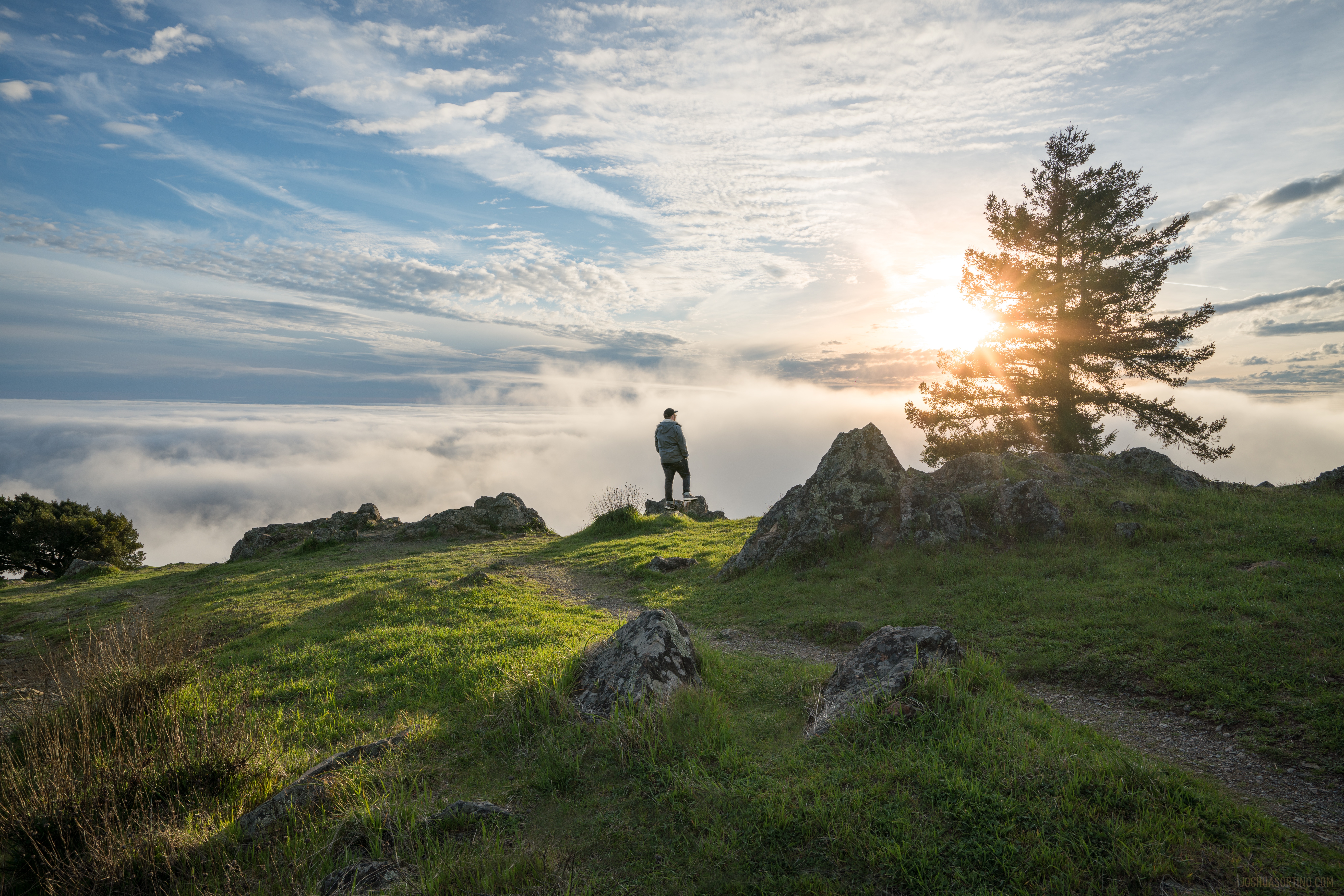 Person standing on a foggy mountain at sunset HD Wallpaper