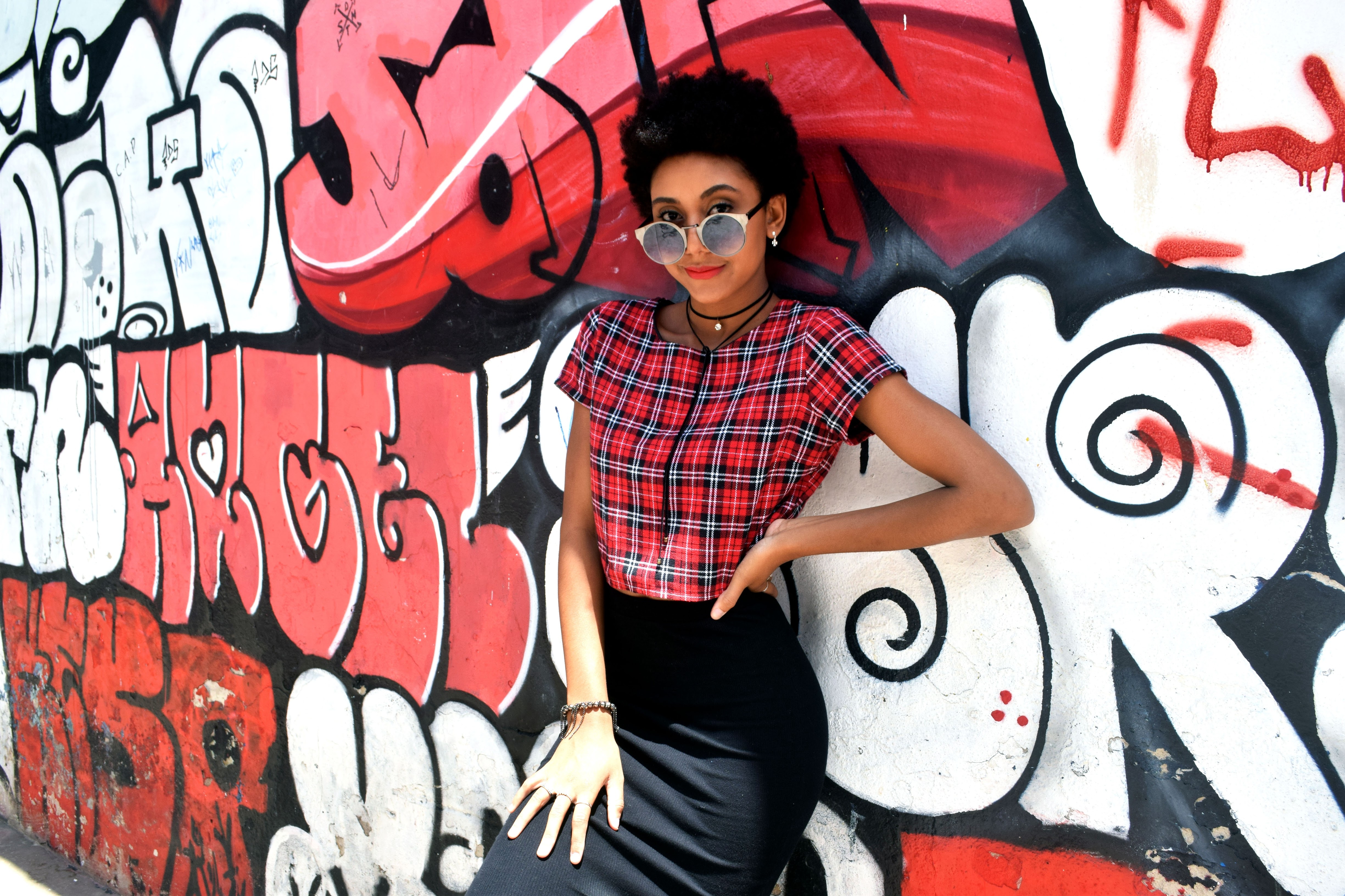Woman in plaid shirt against graffiti wall HD Wallpaper