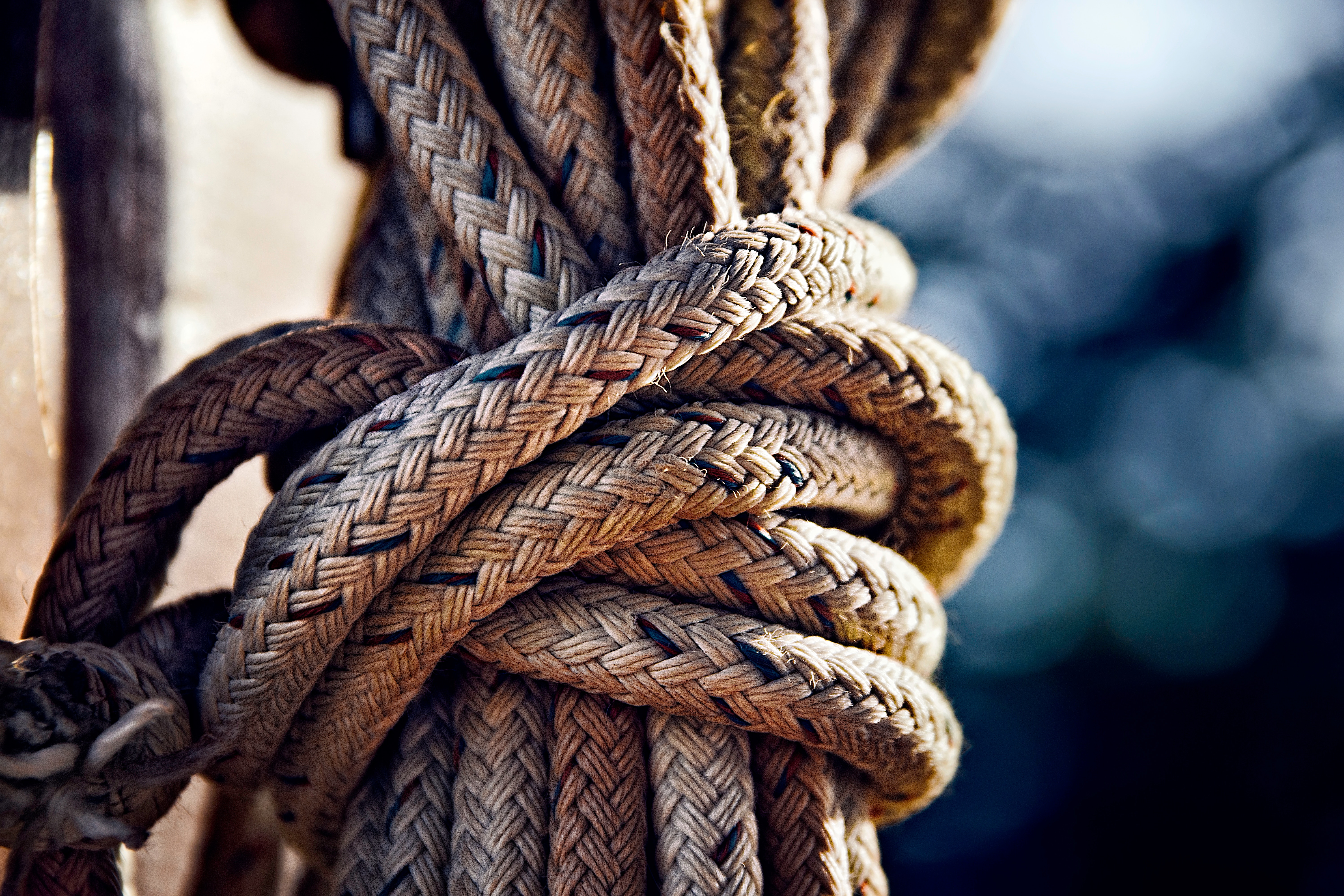 Close-up of a thick braided rope tied in a knot HD Wallpaper