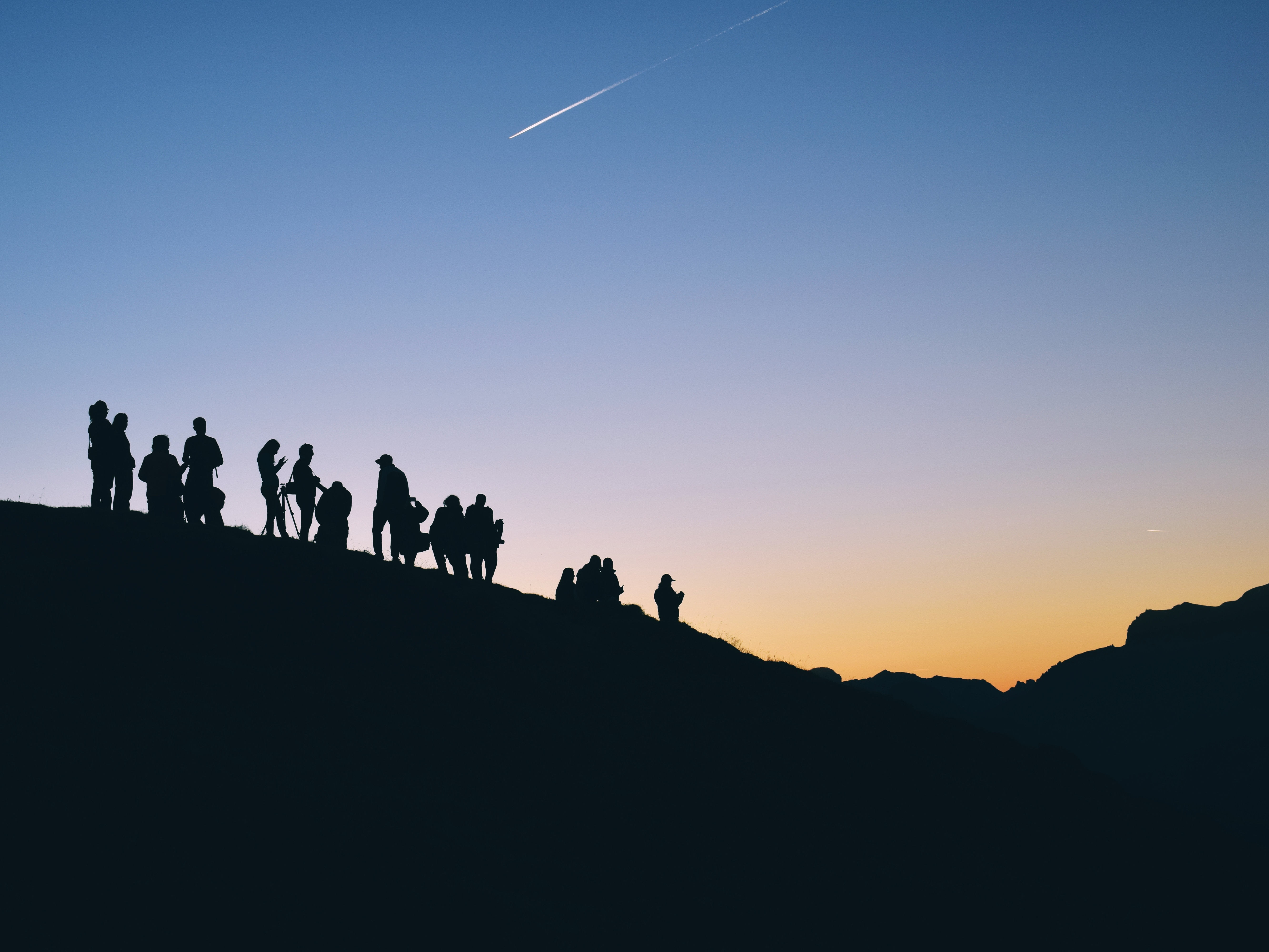 Silhouettes of people on a hill at sunset HD Wallpaper