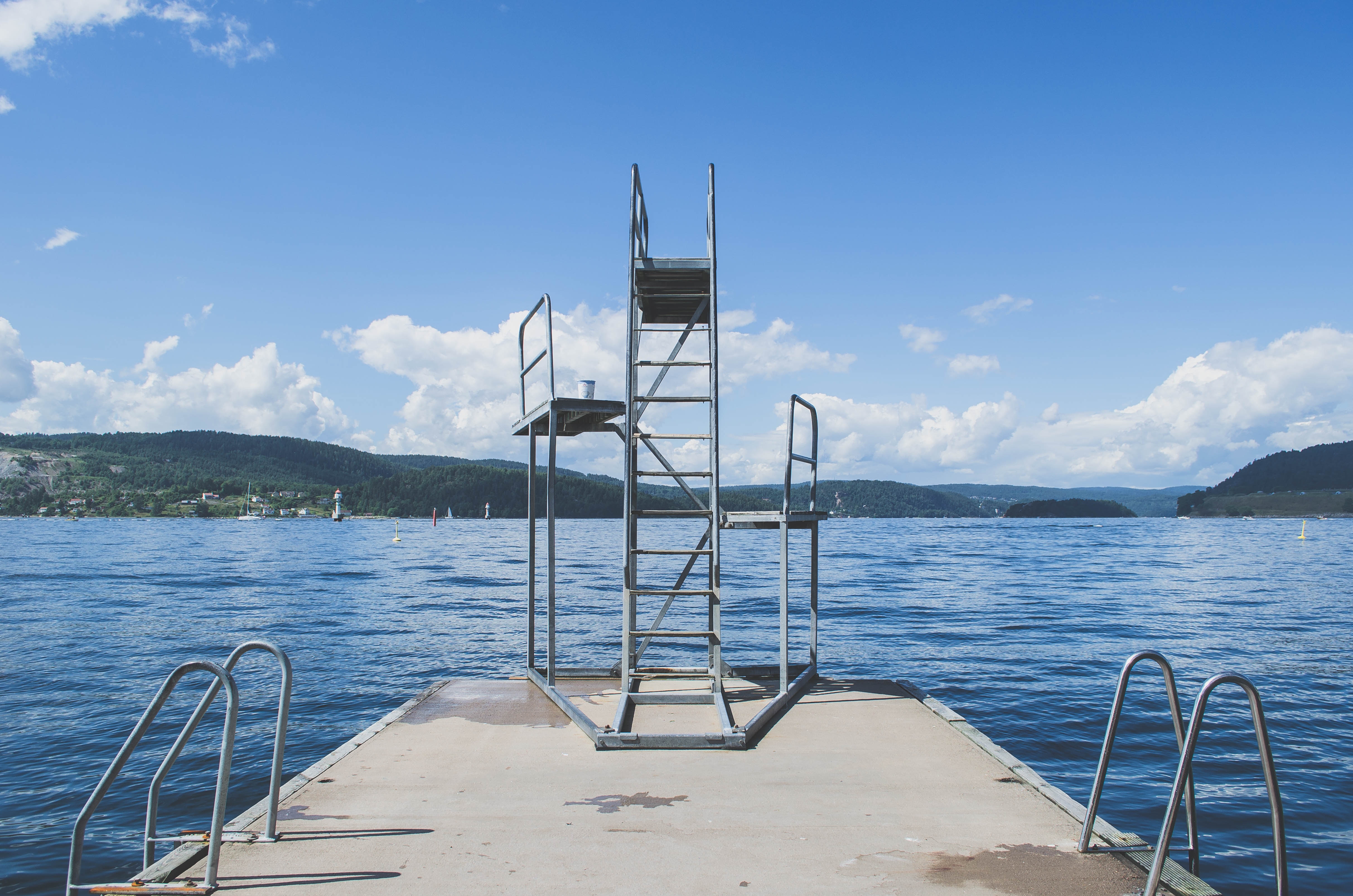 Diving board and ladder on a dock by the sea HD Wallpaper