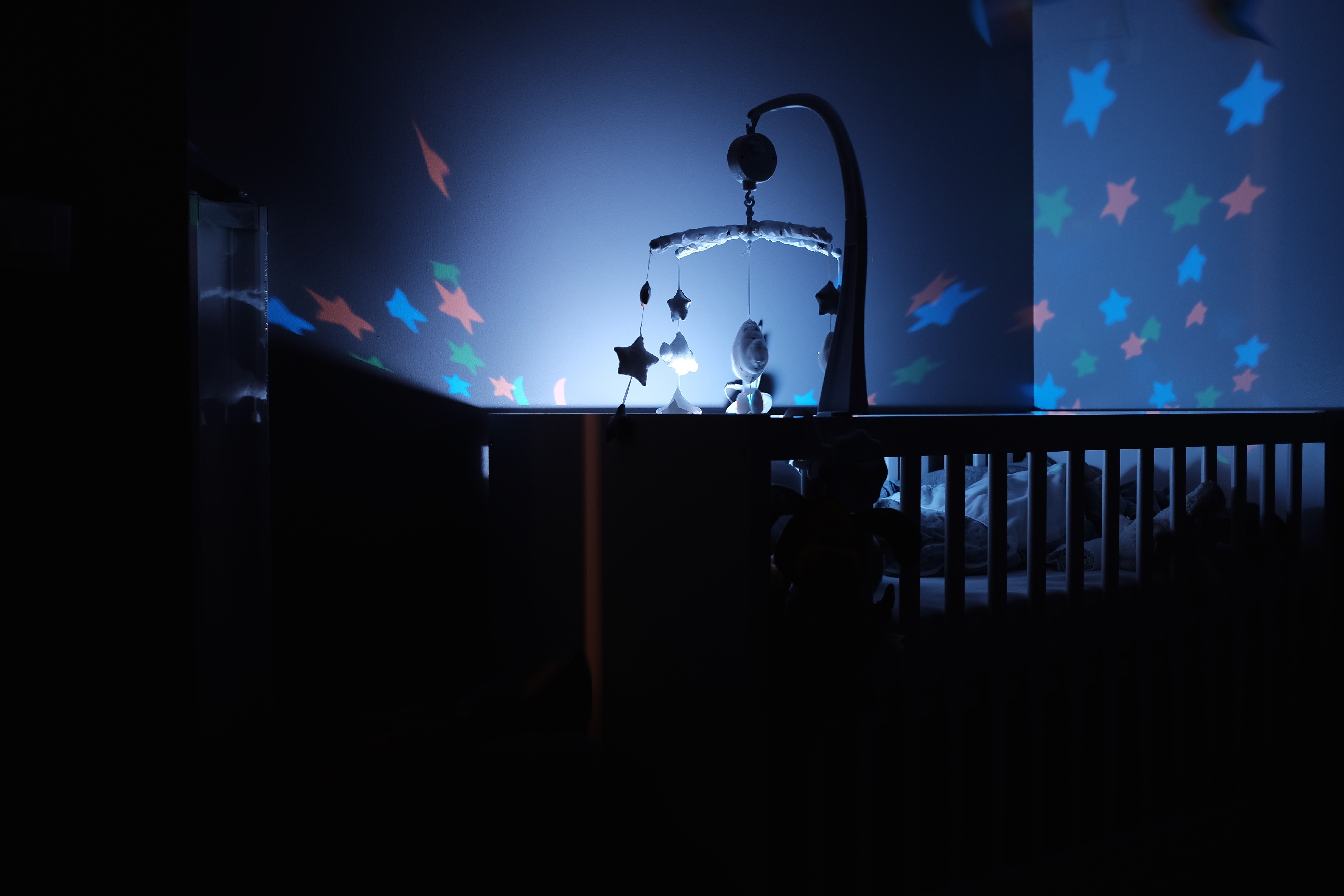 Baby crib with projected stars and mobile HD Wallpaper