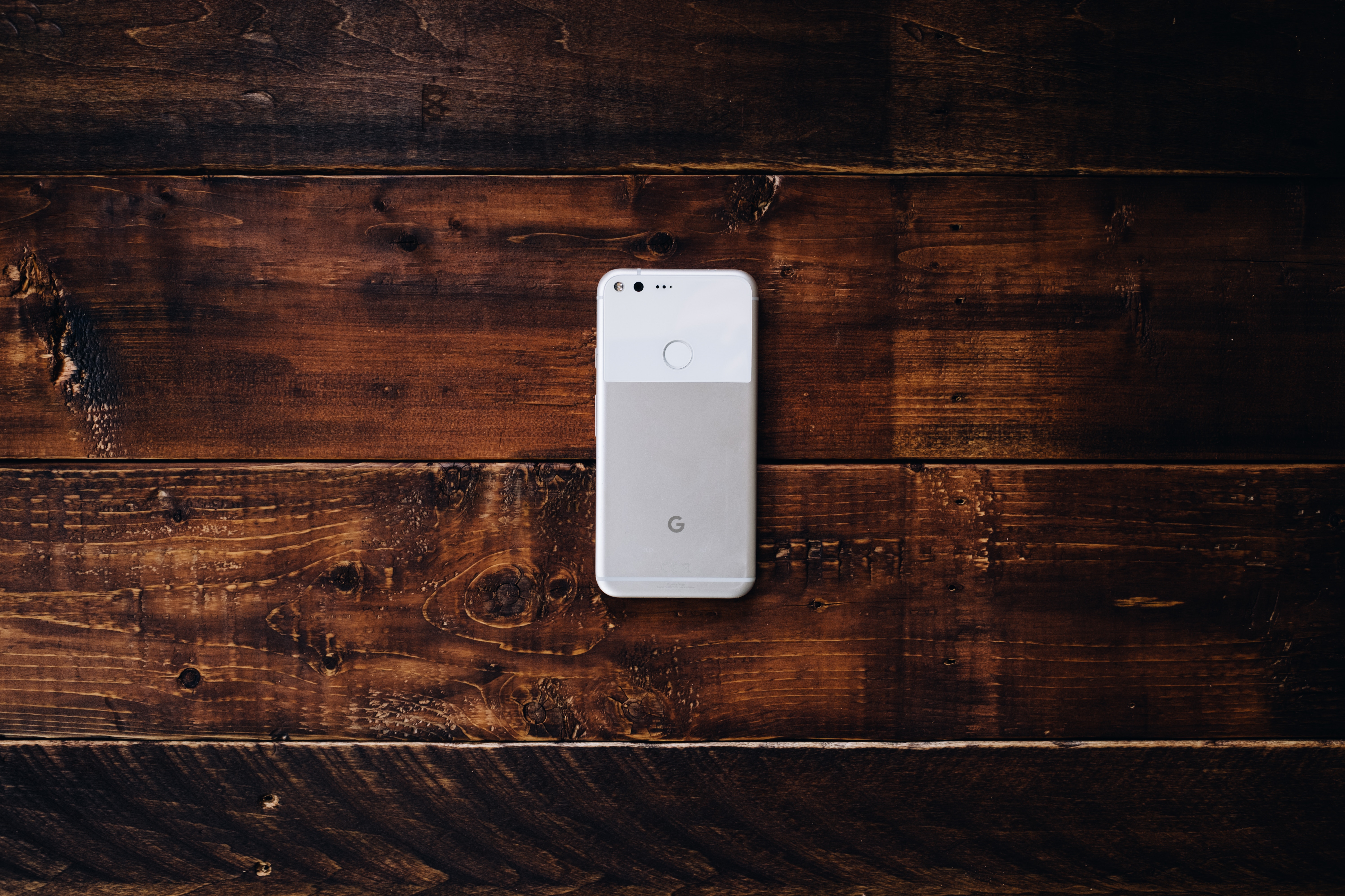 Google Pixel phone on a wooden surface HD Wallpaper